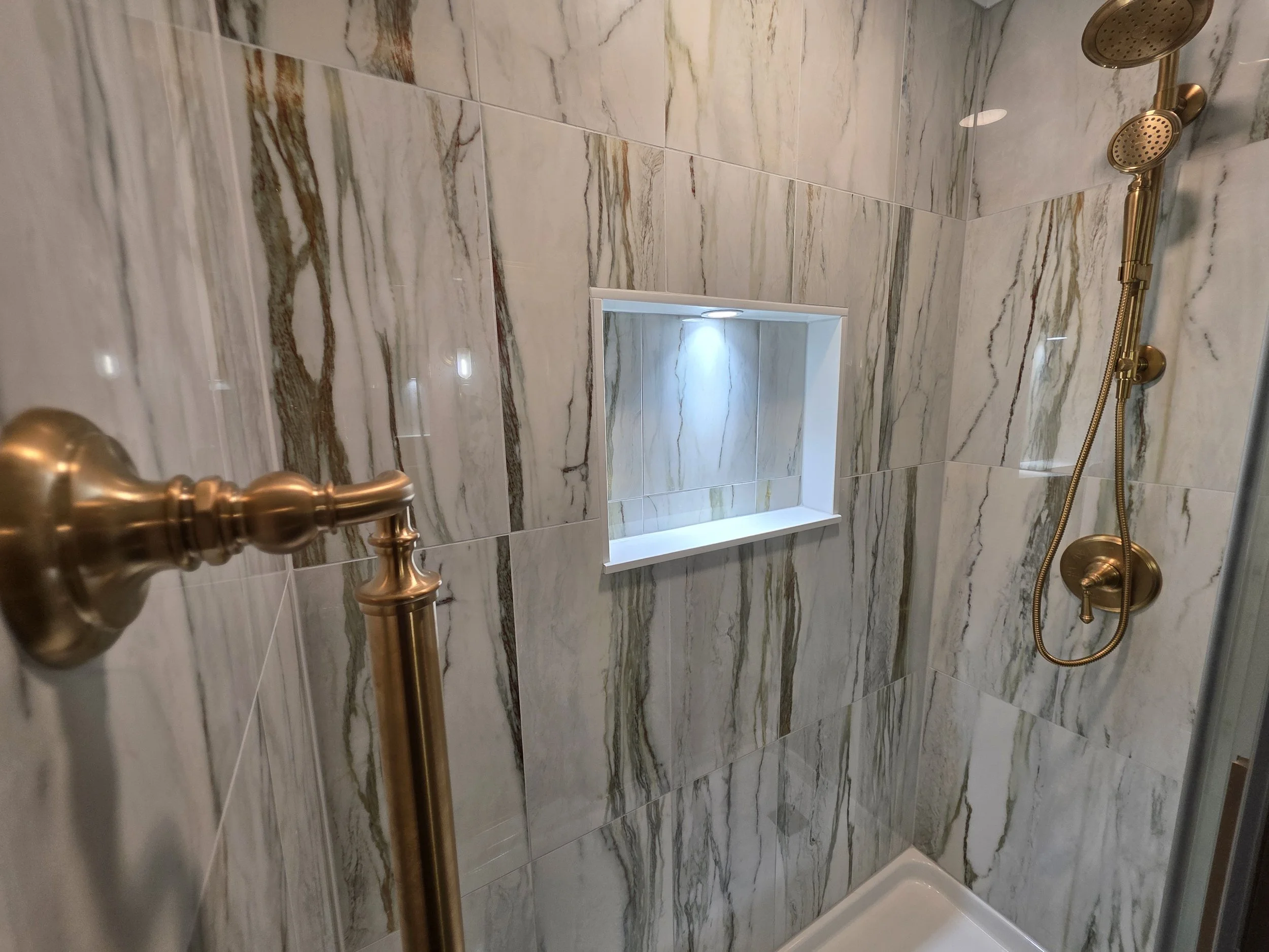 Shower niche and gold-toned rain shower detail.