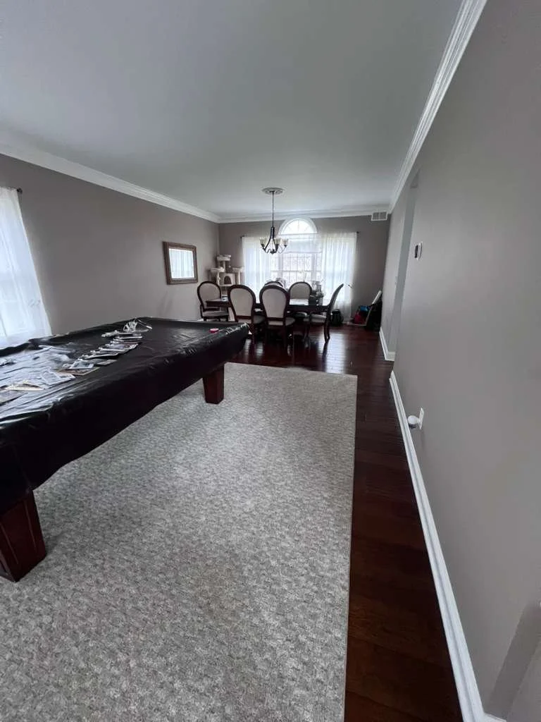 Before renovation: the dining and game room with plain walls and the original light fixture.