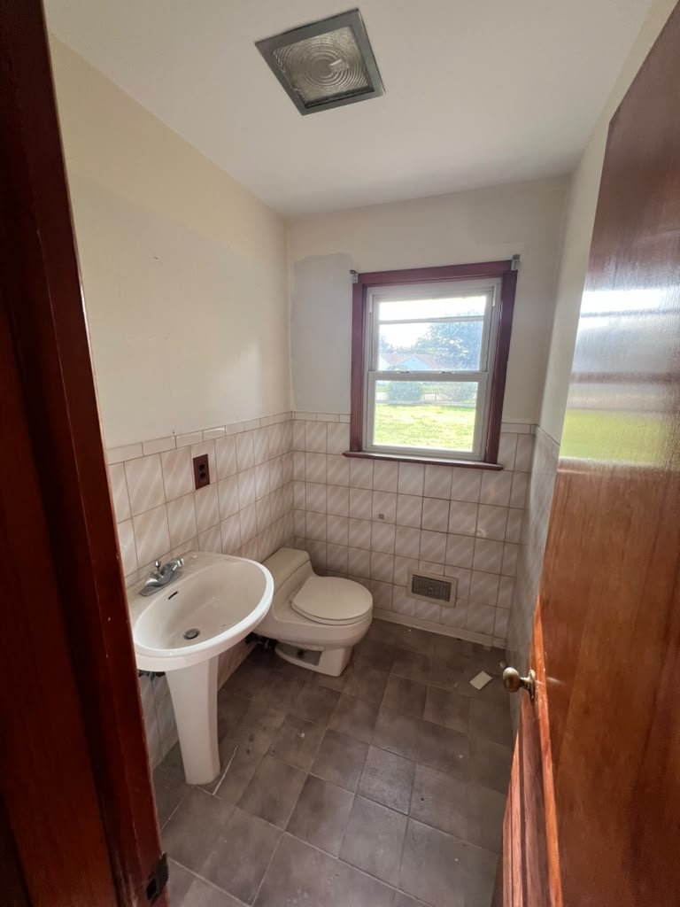 First-floor bathroom before renovation with older tile and sink.