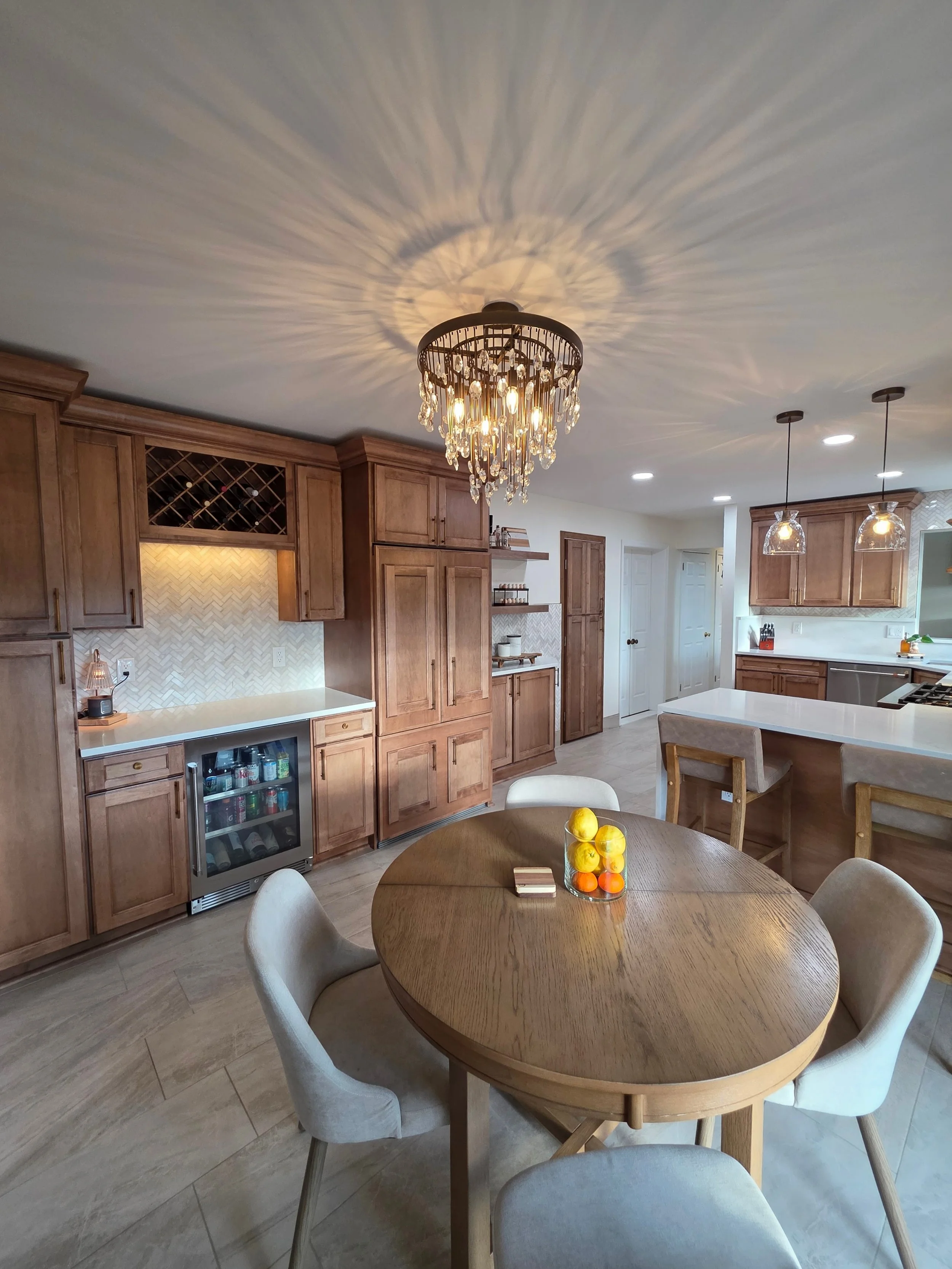 Dining table and decorative ceiling light beside the built-in beverage storage.