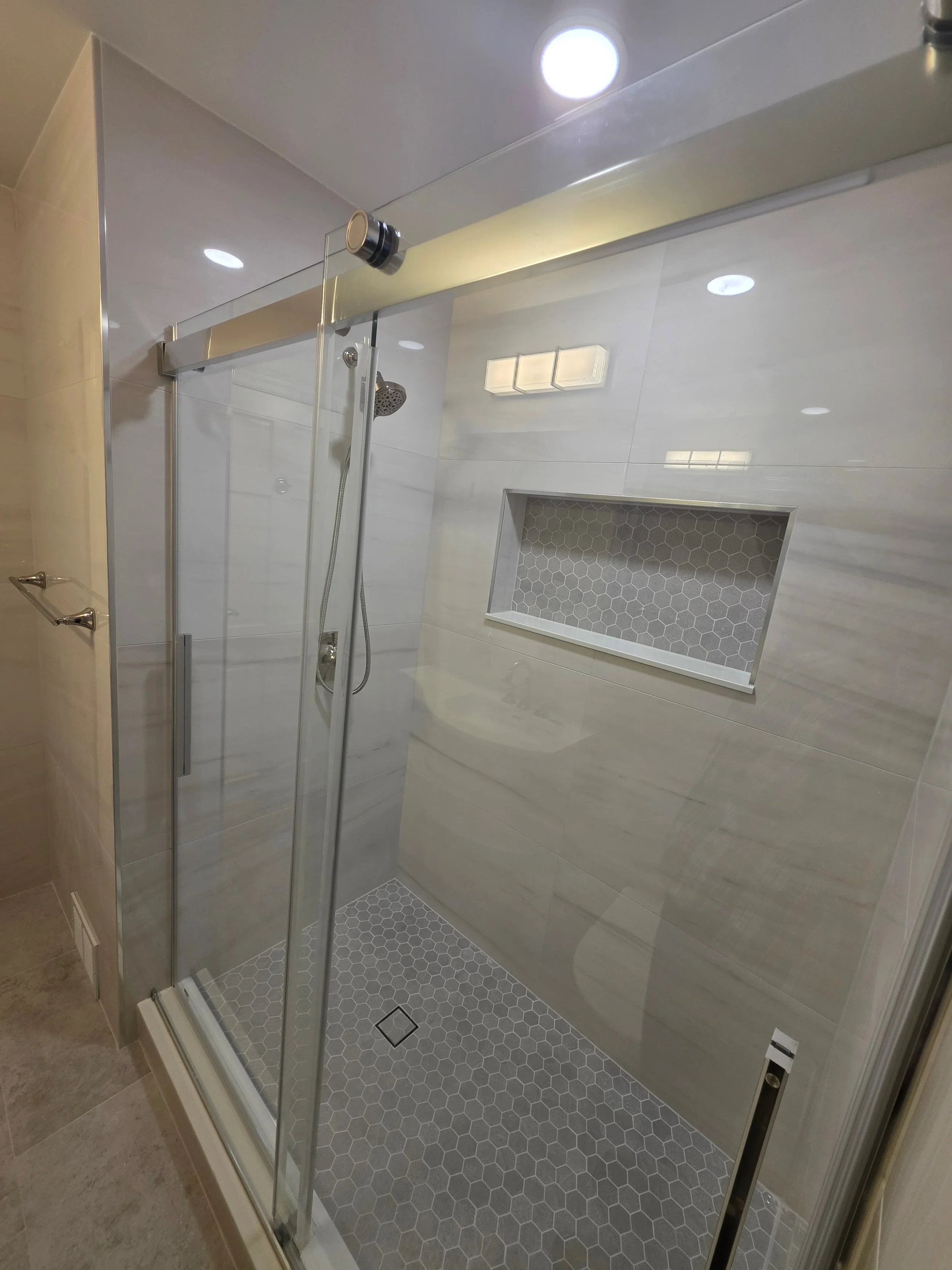 Sliding shower door with recessed wall niche.