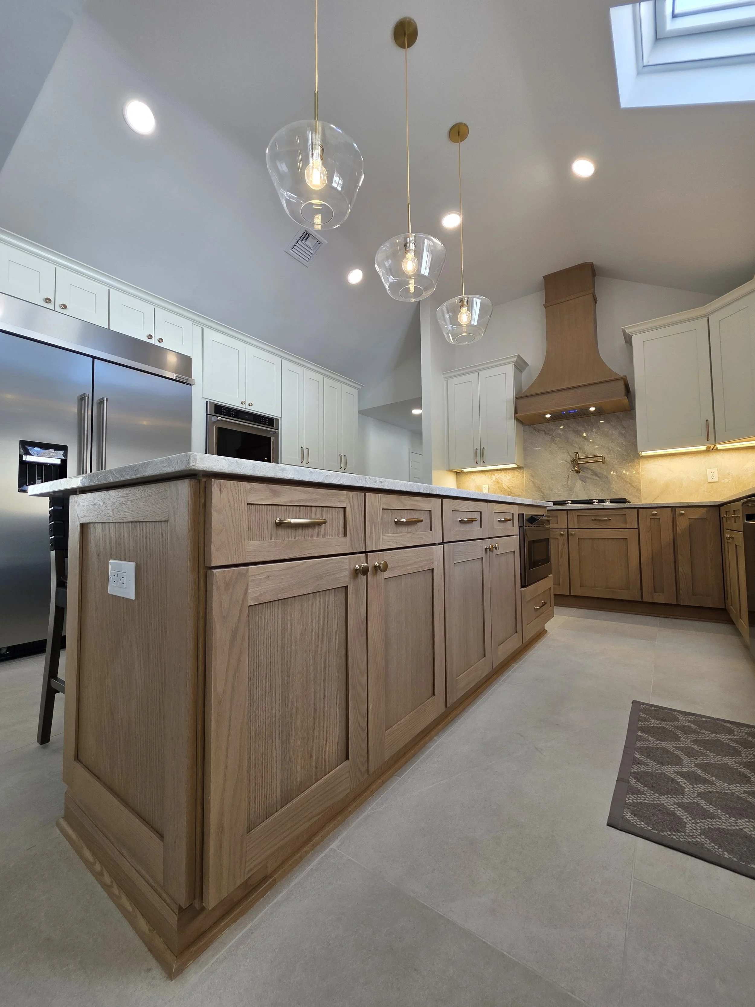 Low view of the island cabinetry and stainless appliances across the kitchen.