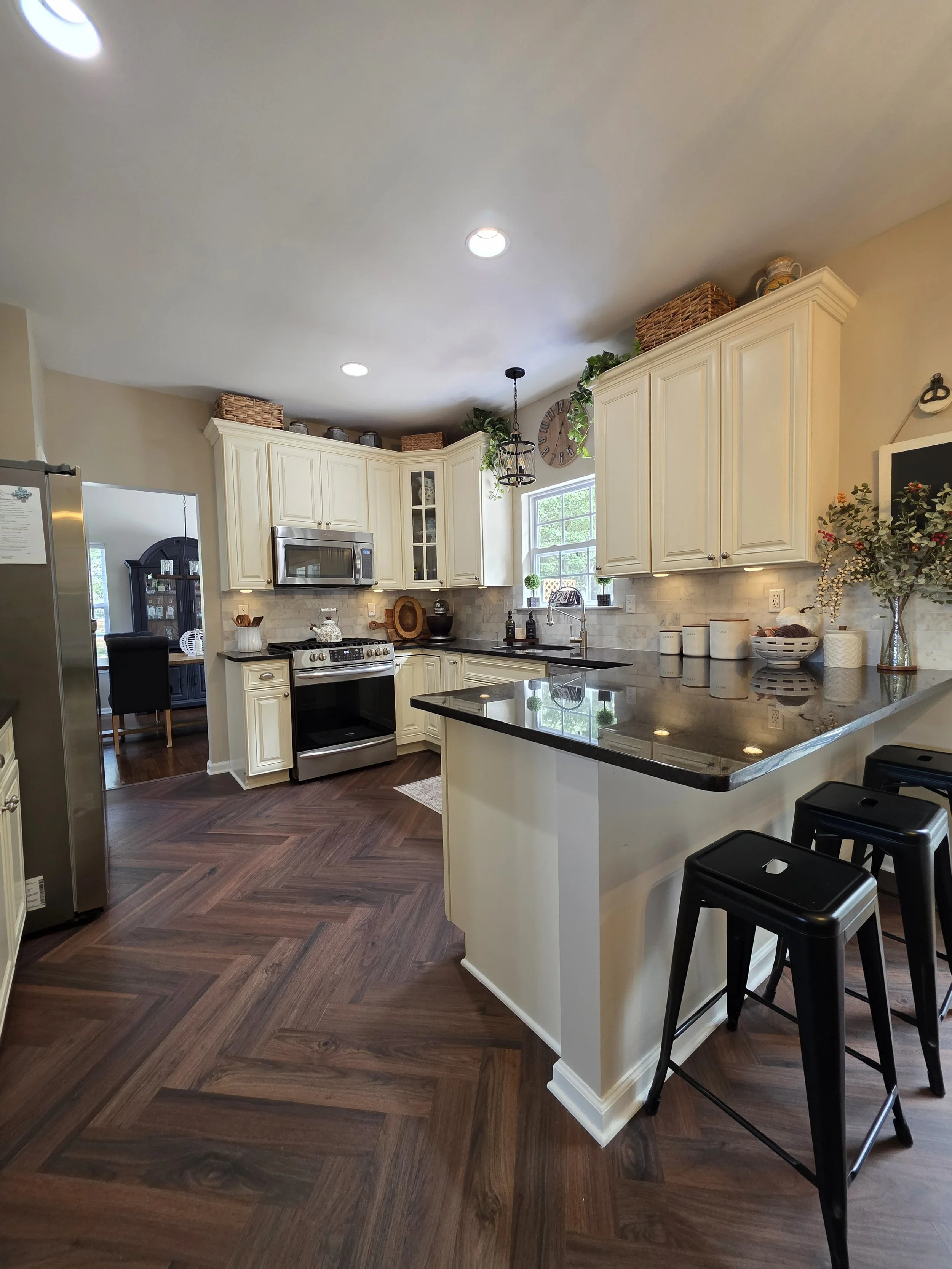 Christina and Michael’s kitchen with new backsplash and herringbone-pattern vinyl floor.