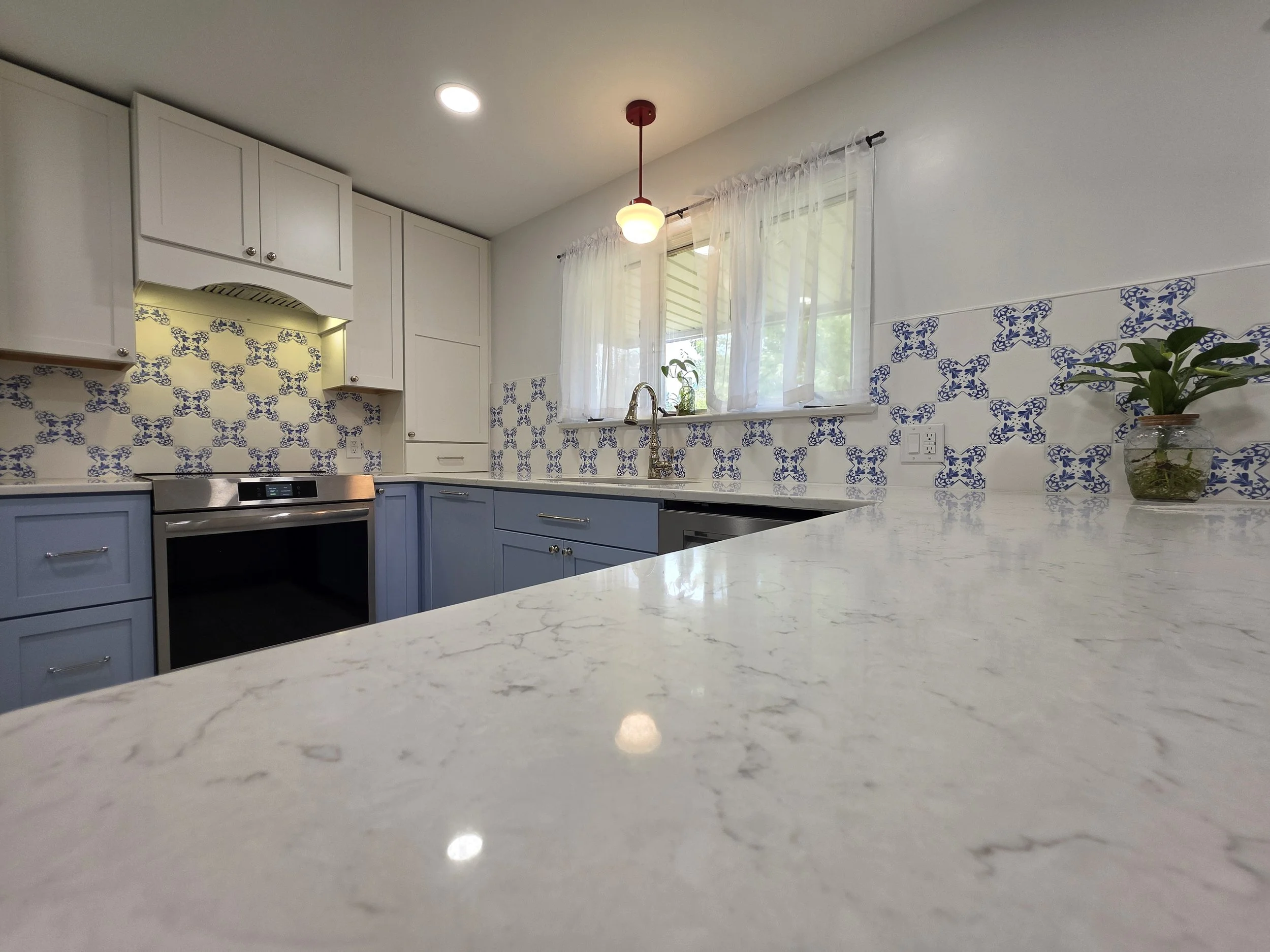 Light countertop and blue patterned backsplash.