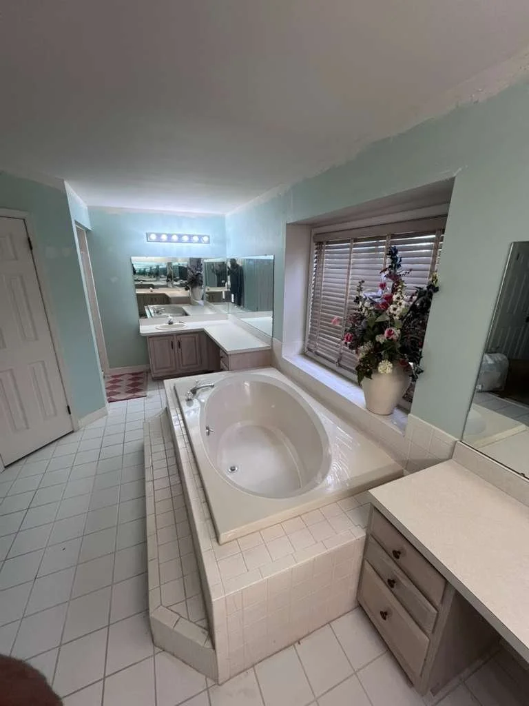 Before renovation: another view of the built-in tub, window and original master bathroom cabinetry.