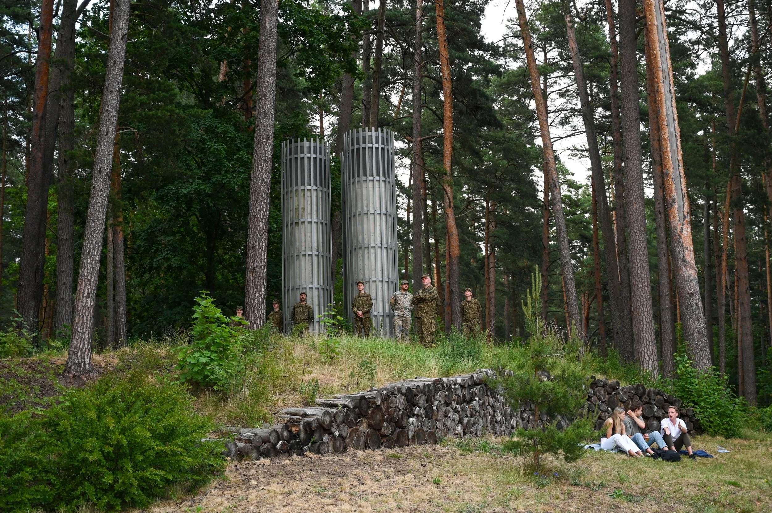 As the song festival went on, the Latvian military stood watch on the outskirts, and alongside them, a group of young adults enjoying a patch of grass