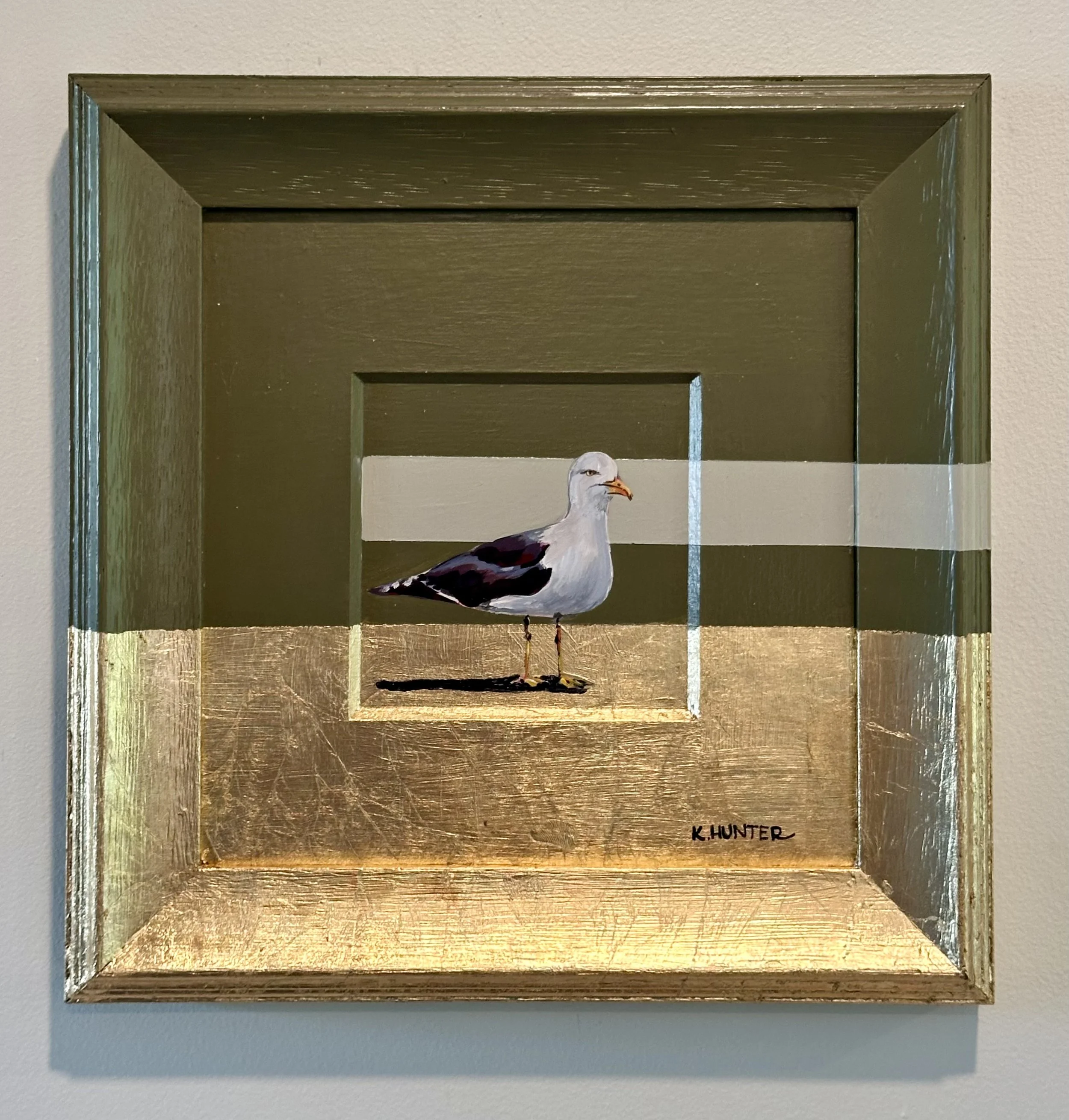 Painting of a seagull standing on a golden surface, with a background featuring a horizontal taupe stripe on a green wall.  new england, coastal art, coastal inspired, new england summer