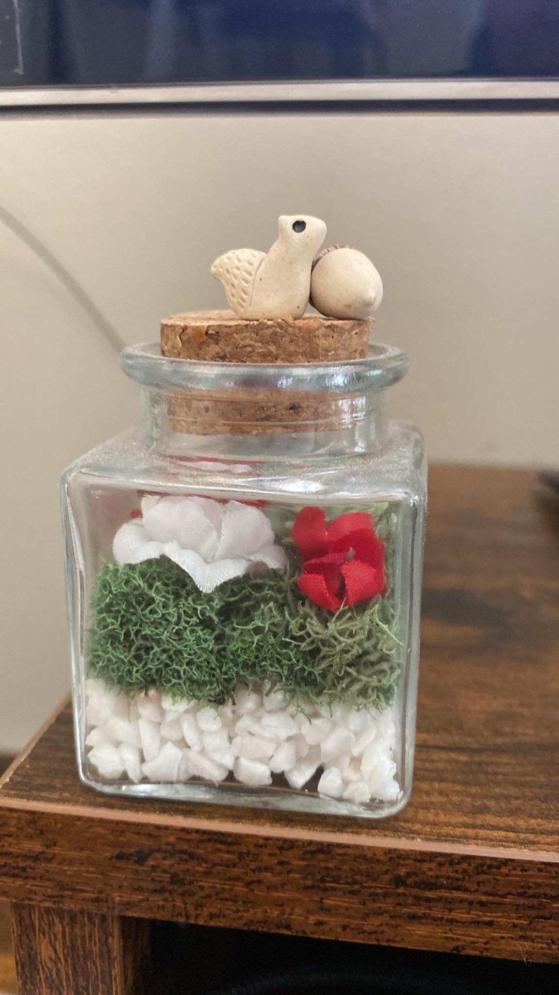 miniature clay squirrel and ceramic acorn sitting together