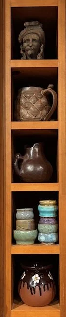 miniature vases by Liza and handmade miniature dishes by Liza stacked together on a shelf in Asheville, NC