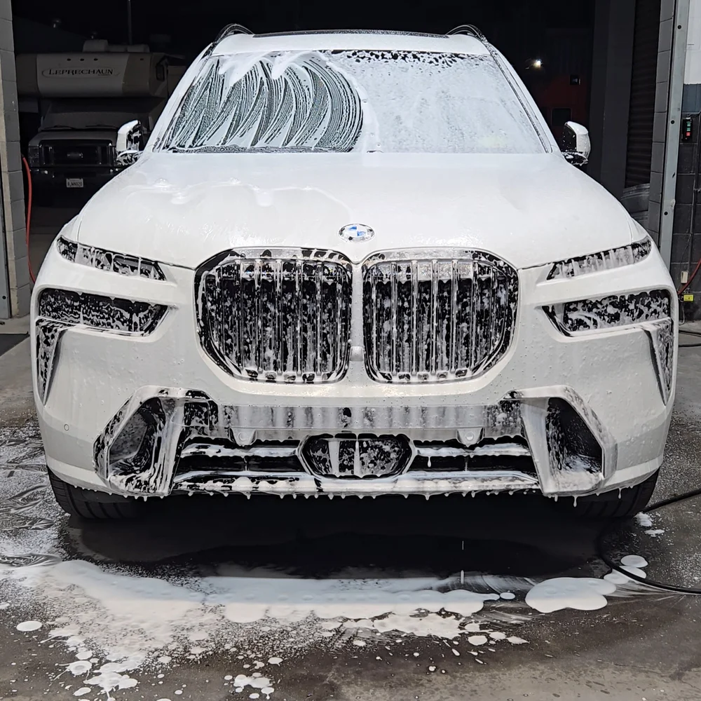 White SUV being foam washed during a detail