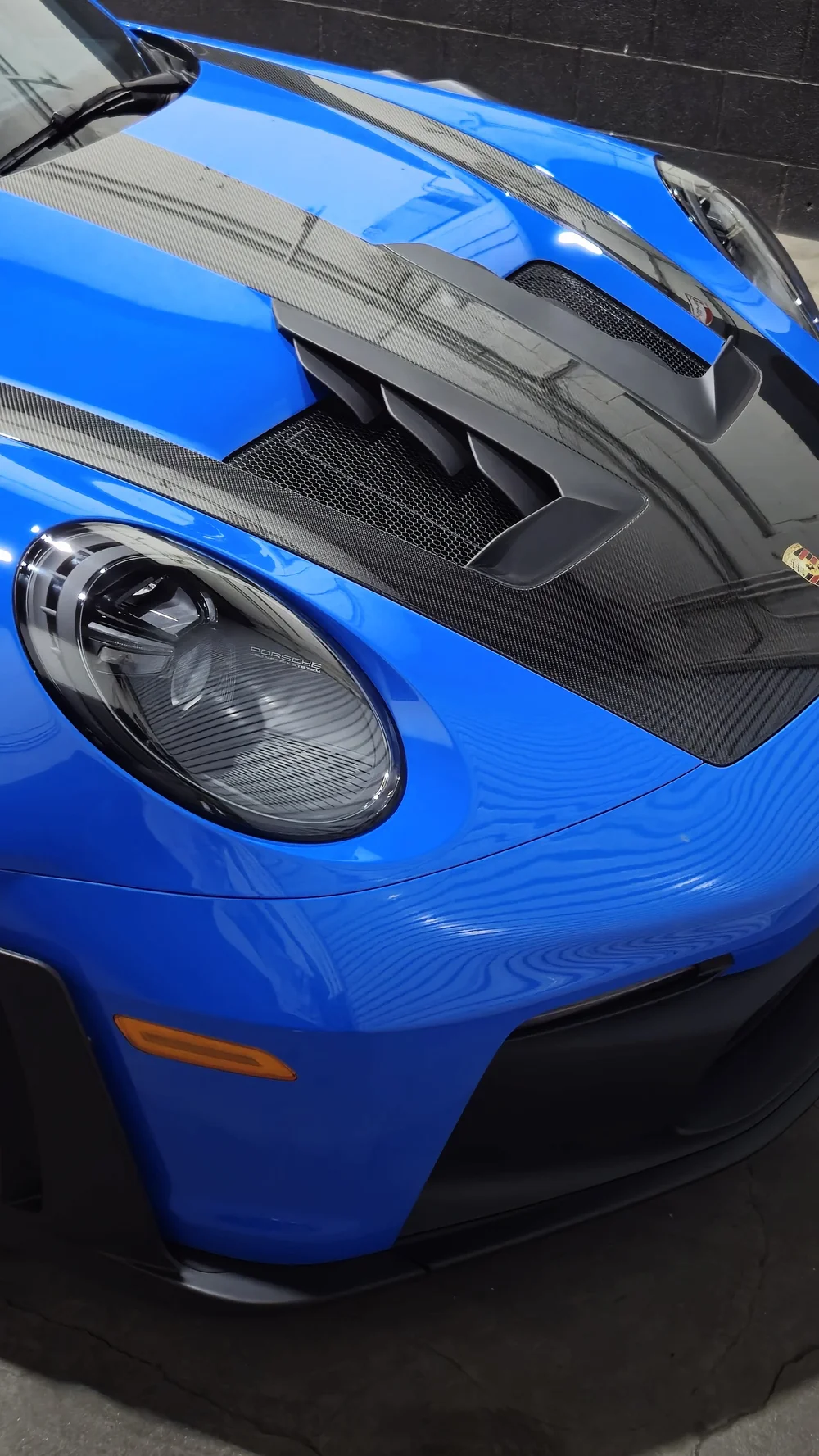 Front end of a blue Porsche GT3 RS protected with paint protection film