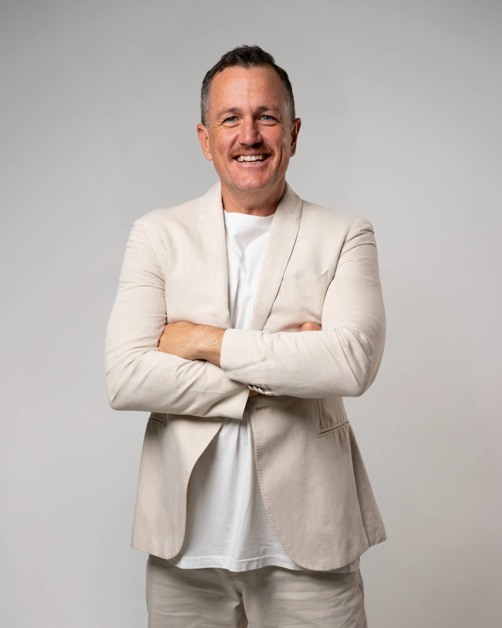 Studio headshot of a professional man in business-casual attire, created for a corporate website profile