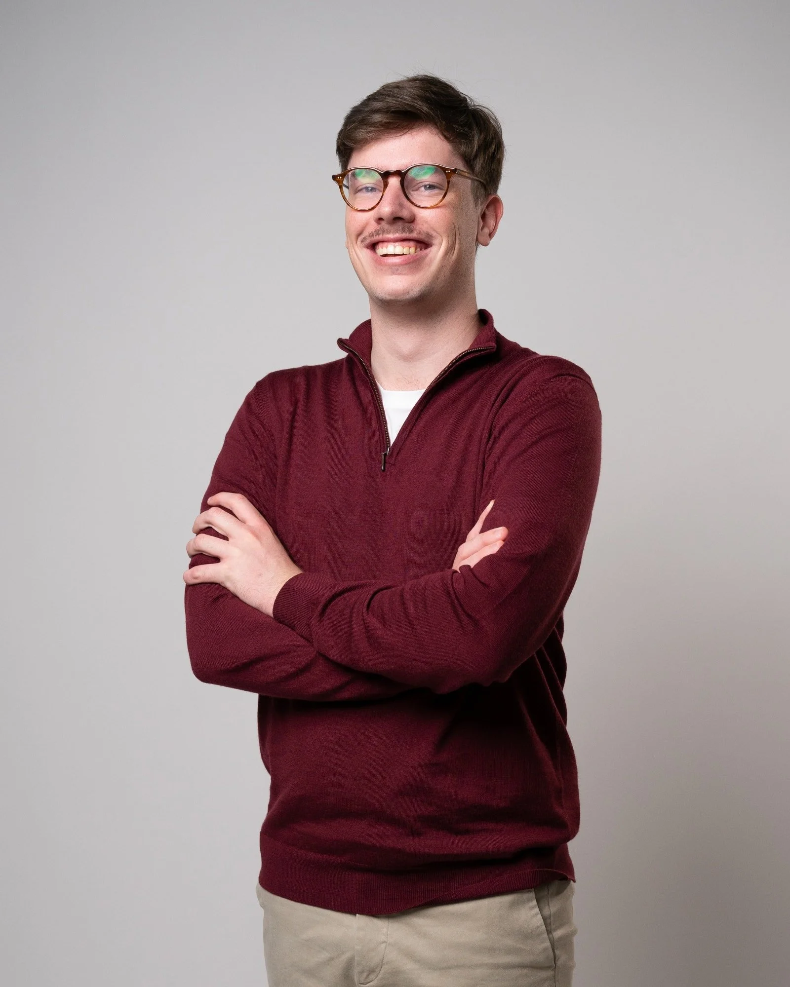 Professional studio headshot of a man in business-casual attire, styled for a corporate website