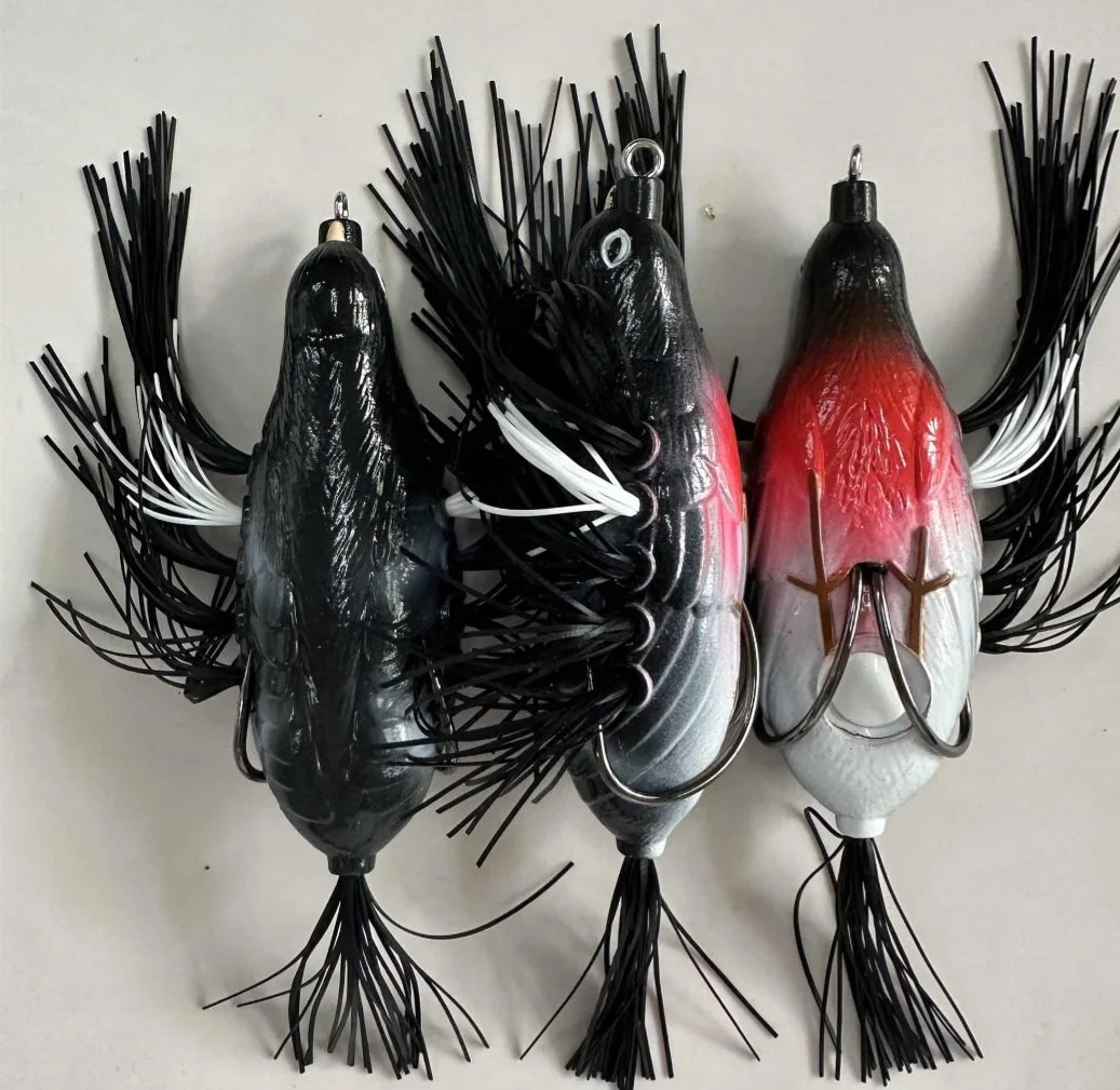 Three fishing lures designed to look like fish, with black, white, gray, and red coloring, arranged opposite each other.