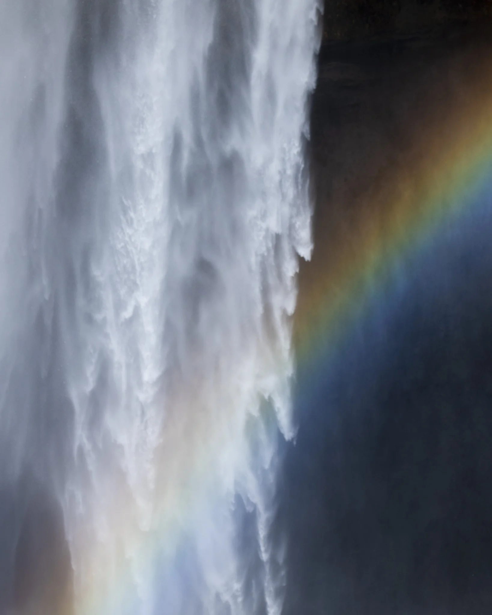 A waterfall with a rainbow in the mist.