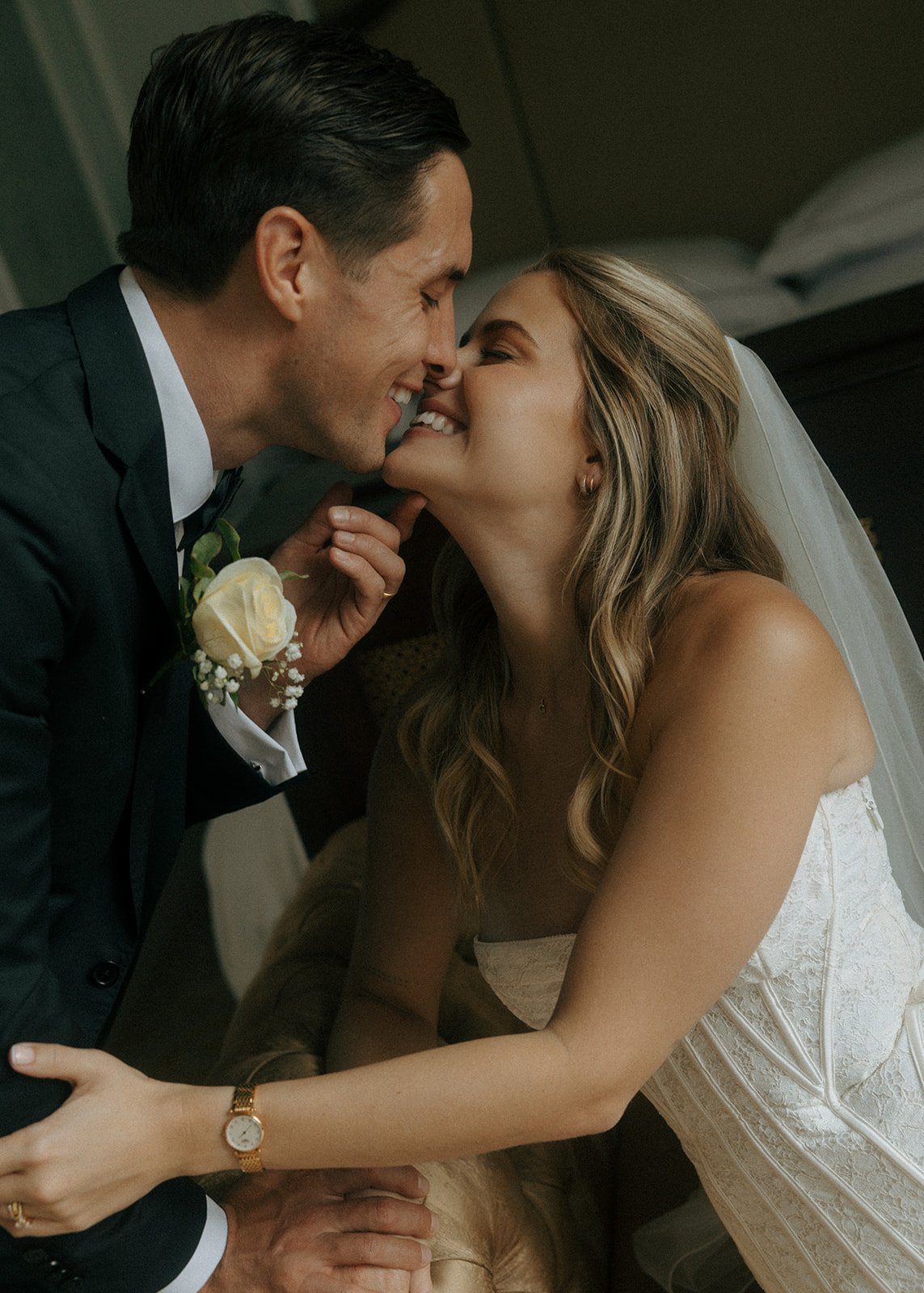A couple in wedding attire exchanging vows in a forest with tall trees, sunlight filtering through the branches, and a dirt ground.