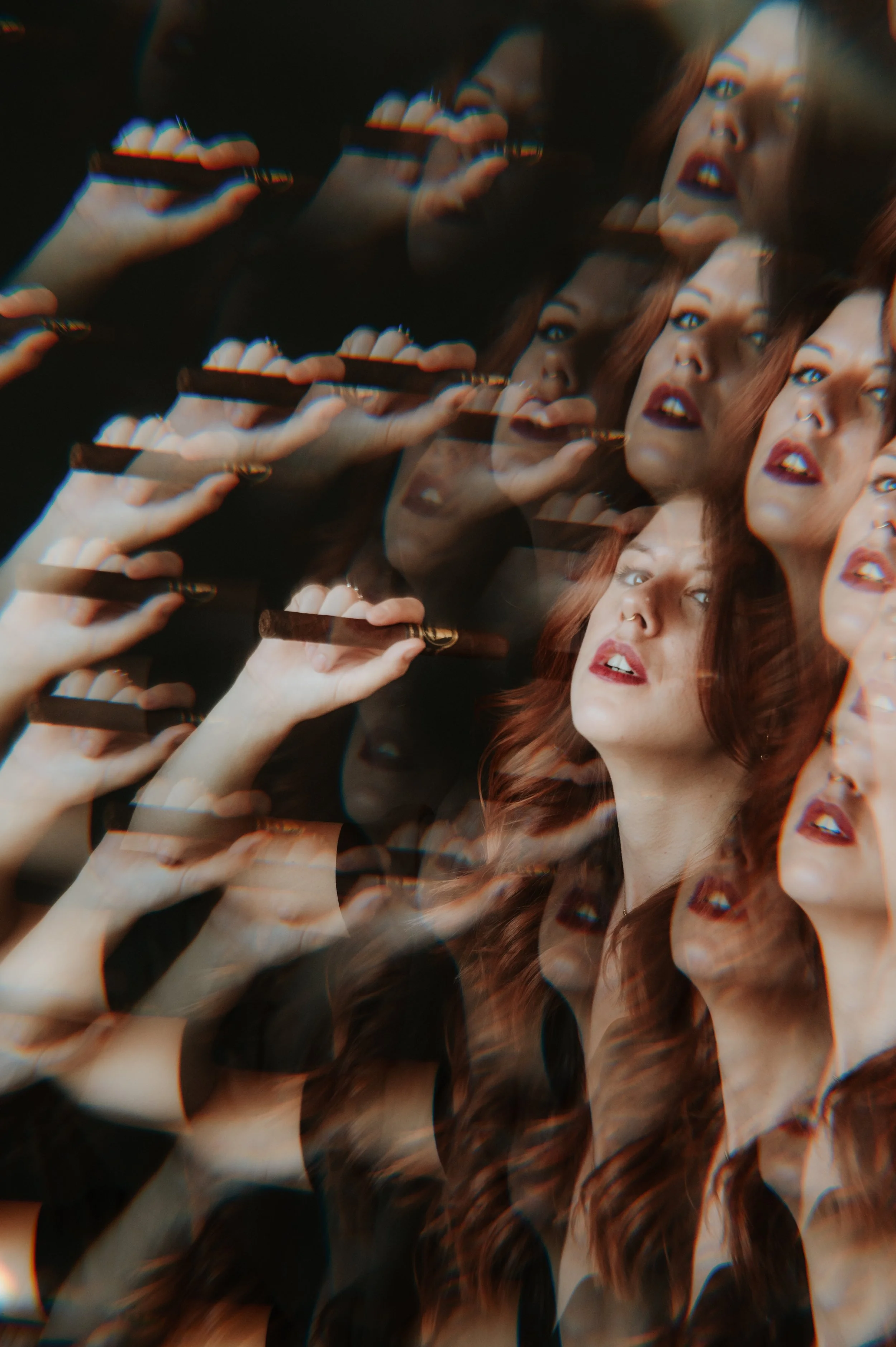 A woman with red hair and makeup holding a cigarette, with multiple overlapping and distorted images of herself creating a surreal, layered effect.