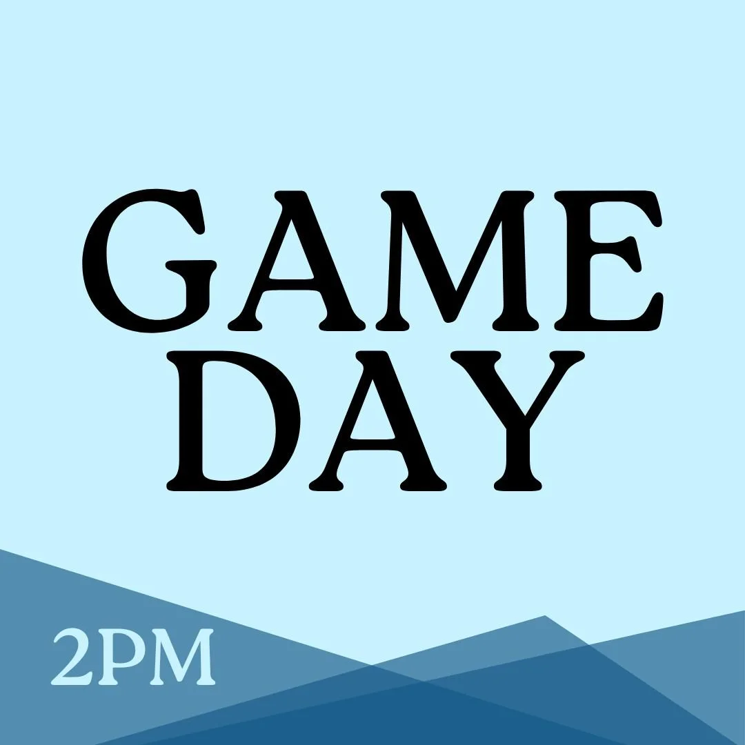 Silhouette of a mountain range with the sun setting or rising behind it, creating a glowing effect in the sky with orange, yellow, and blue hues.