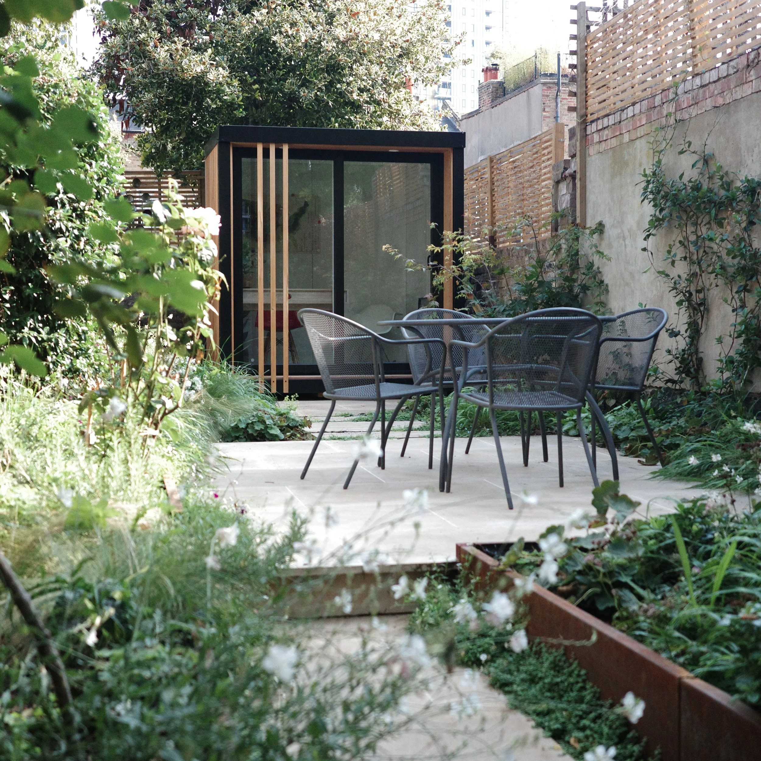 Tucked amongst the surrounding high rises, this garden offers a private, green retreat from the pace of city life.

Lush, layered planting creates a sense of enclosure and calm, complemented by craft-led materials and considered detailing. A new outd