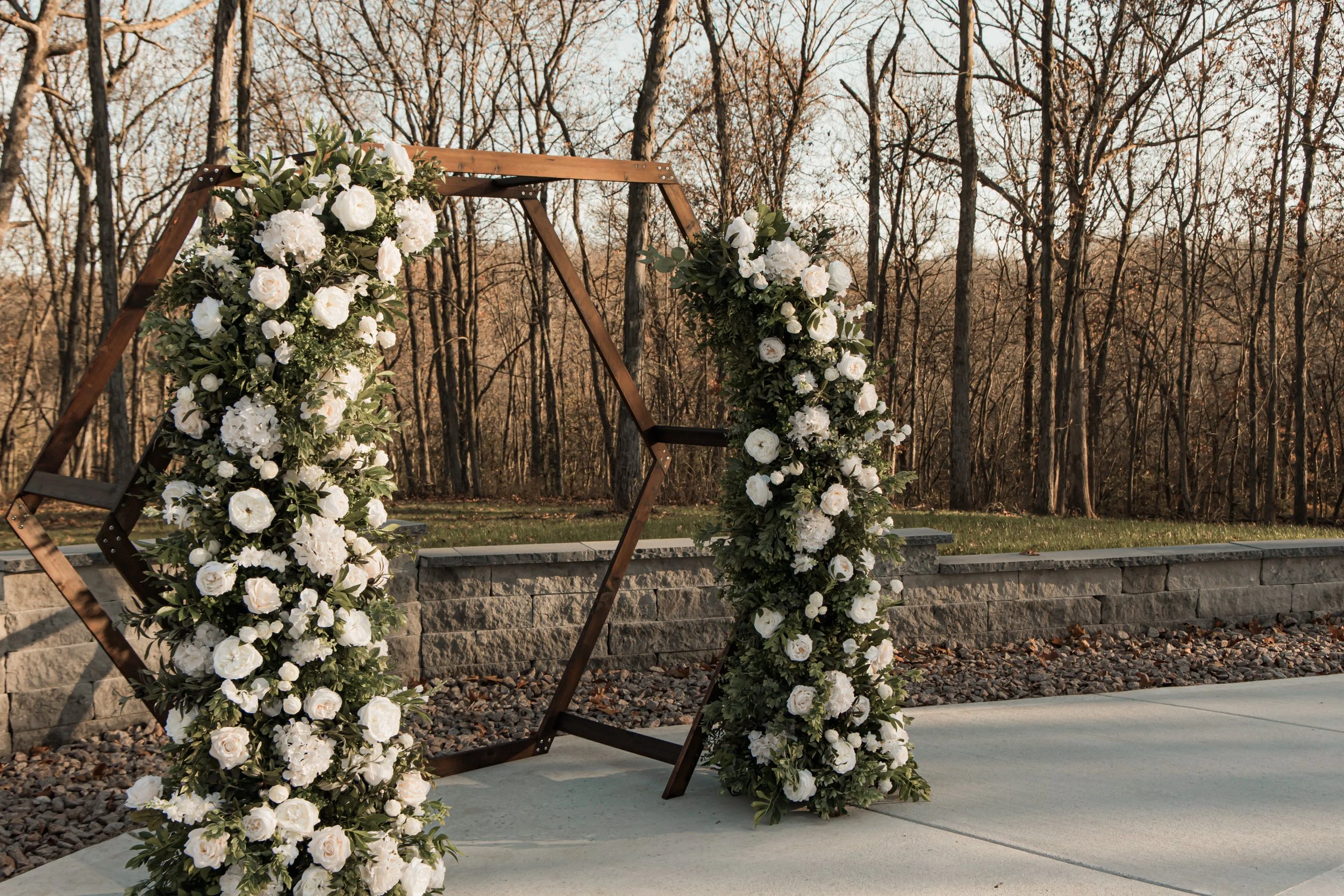 Floral arch with white flowers in a forest setting