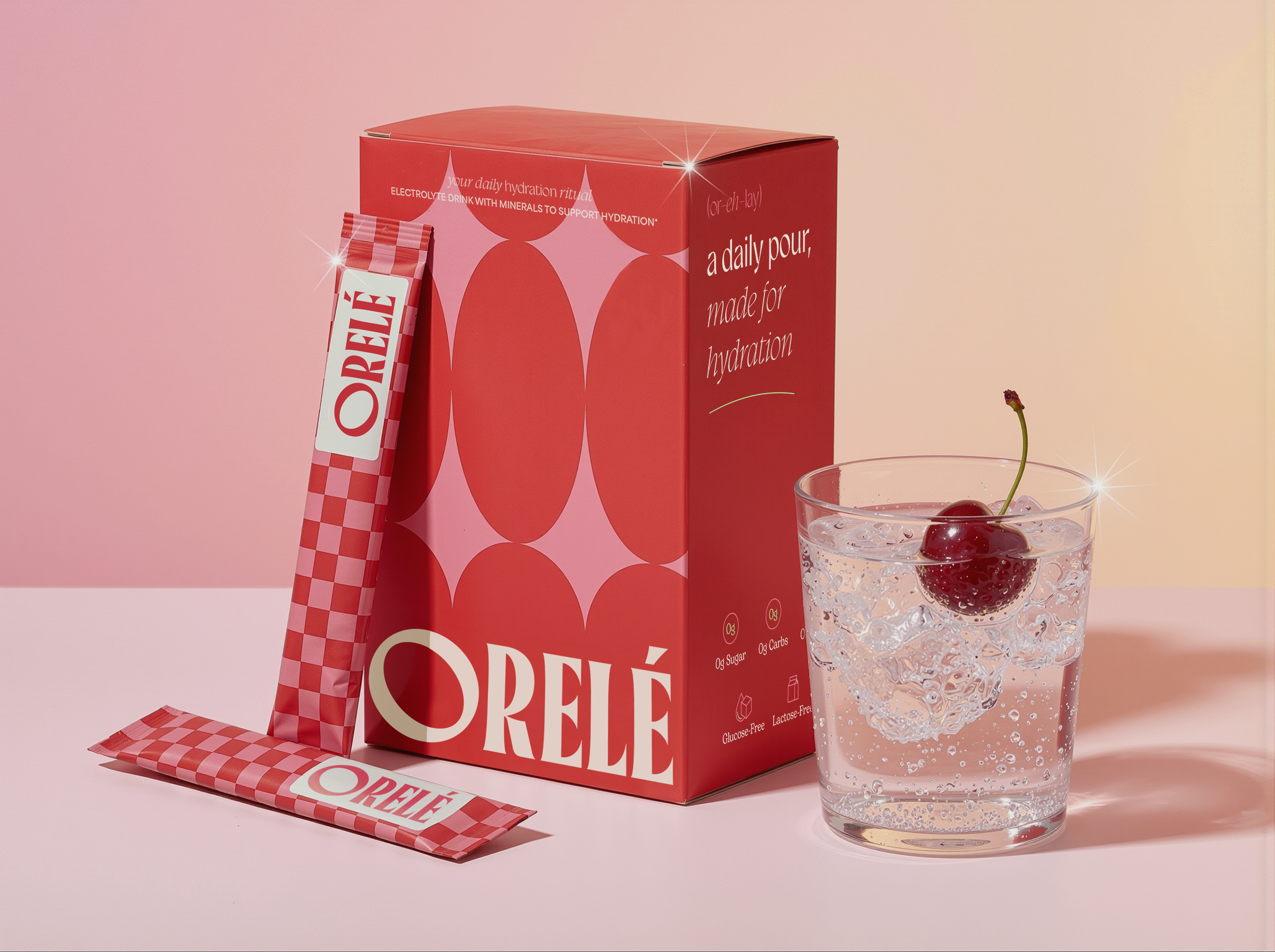 A red box of OREÈLE hydration drink and a matching straw with a checkered pattern, alongside a glass of sparkling water with ice and cherries, set against a pink gradient background.
