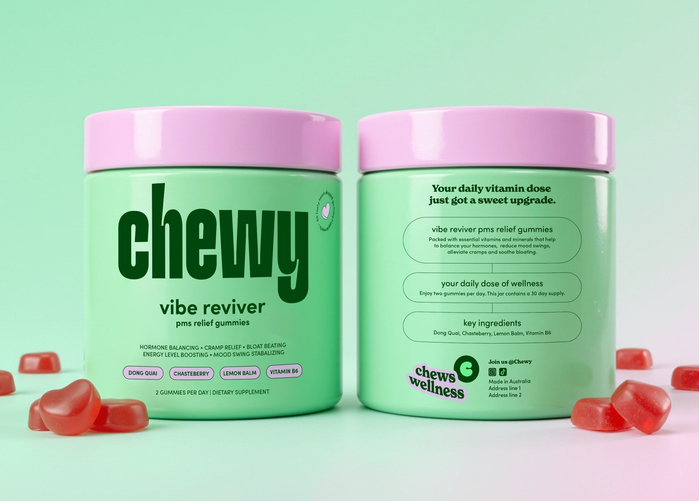 Close-up of two containers of chewy wellness vibe reviver PMS relief gummies with pink caps and label text, surrounded by pink heart-shaped gummies on a pastel green background.