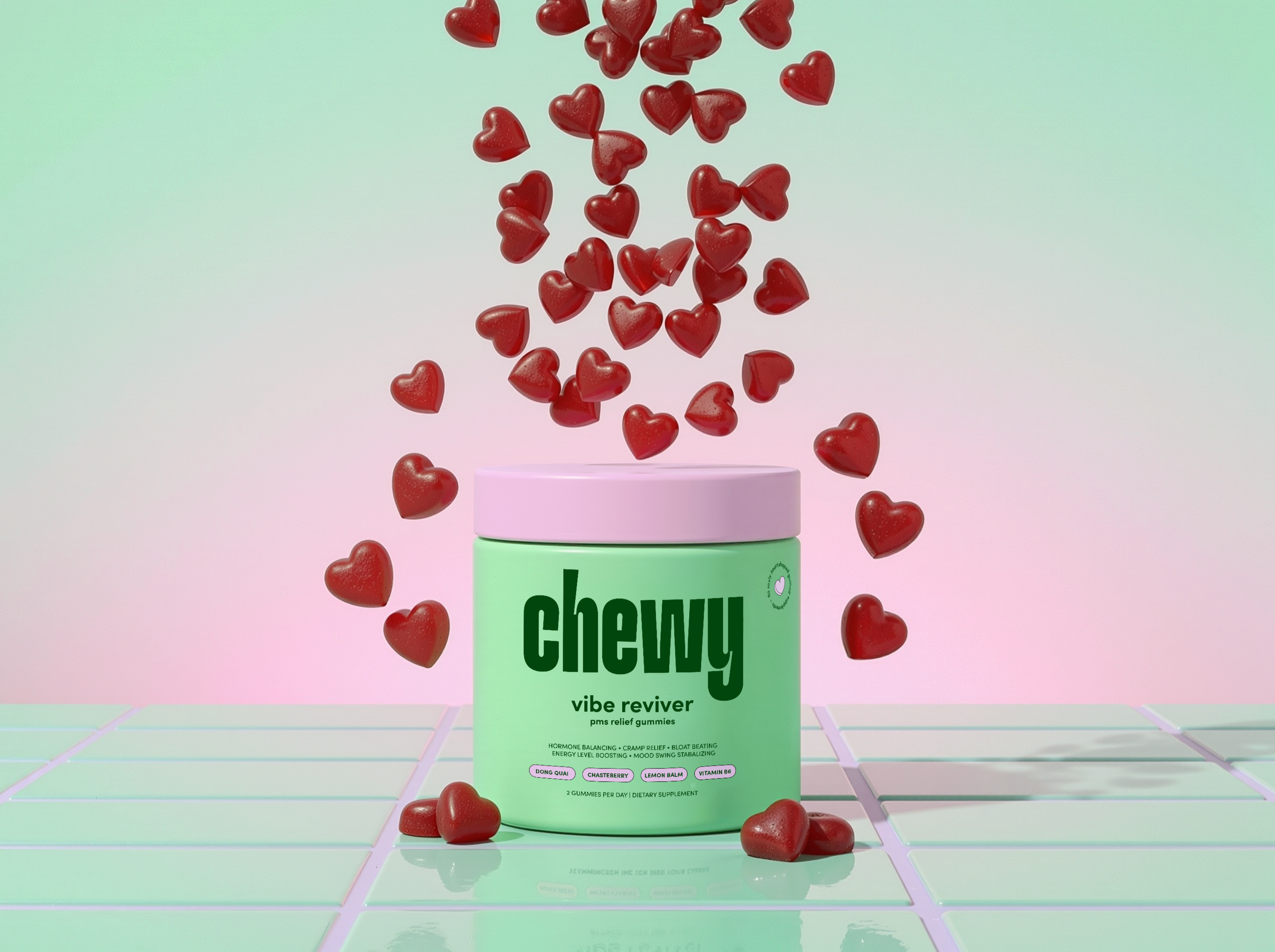 A green container labeled "Chewy" with the words "vibe reviver" and descriptions of benefits like hormone balancing, cramp relief, and energy boosting. Red heart-shaped gummies are falling into or out of the container, with some on the surface below.
