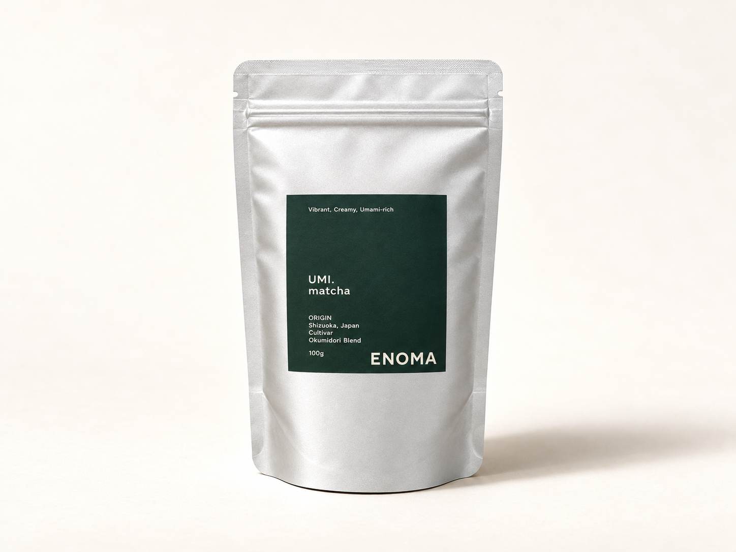 Paquet gris 100g de thé matcha UMI de la marque ENOMA avec étiquetage vert foncé et texte blanc indiquant l'origine Japan et les caractéristiques du produit.