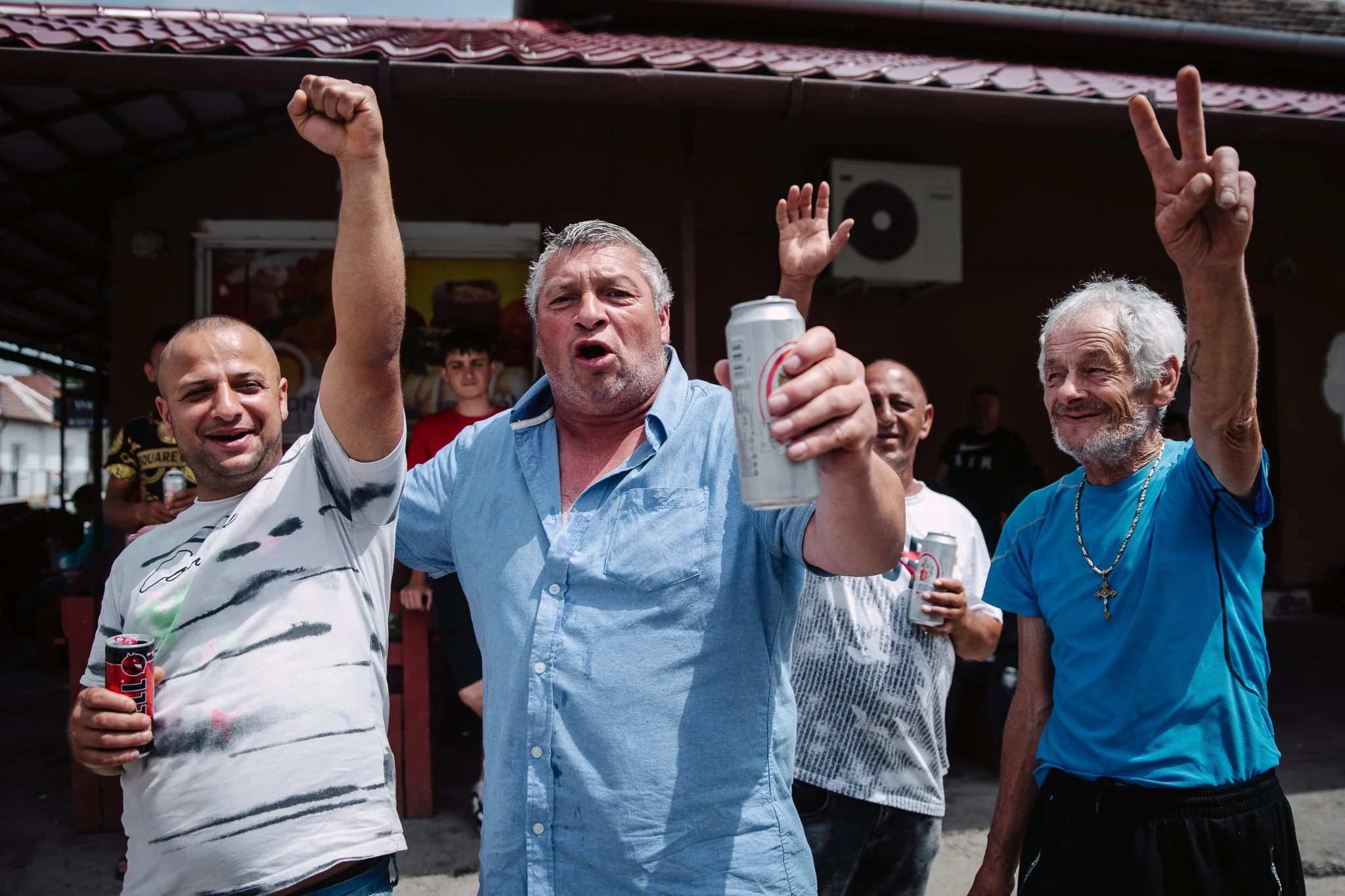 Men celebrate in front of the local national tobacco shop. Although it's only afternoon and voting is still in full swing, many around the tobacco shop are already in a flush of victory. There's a big crowd of CiKöSz supporters gathering here. One of