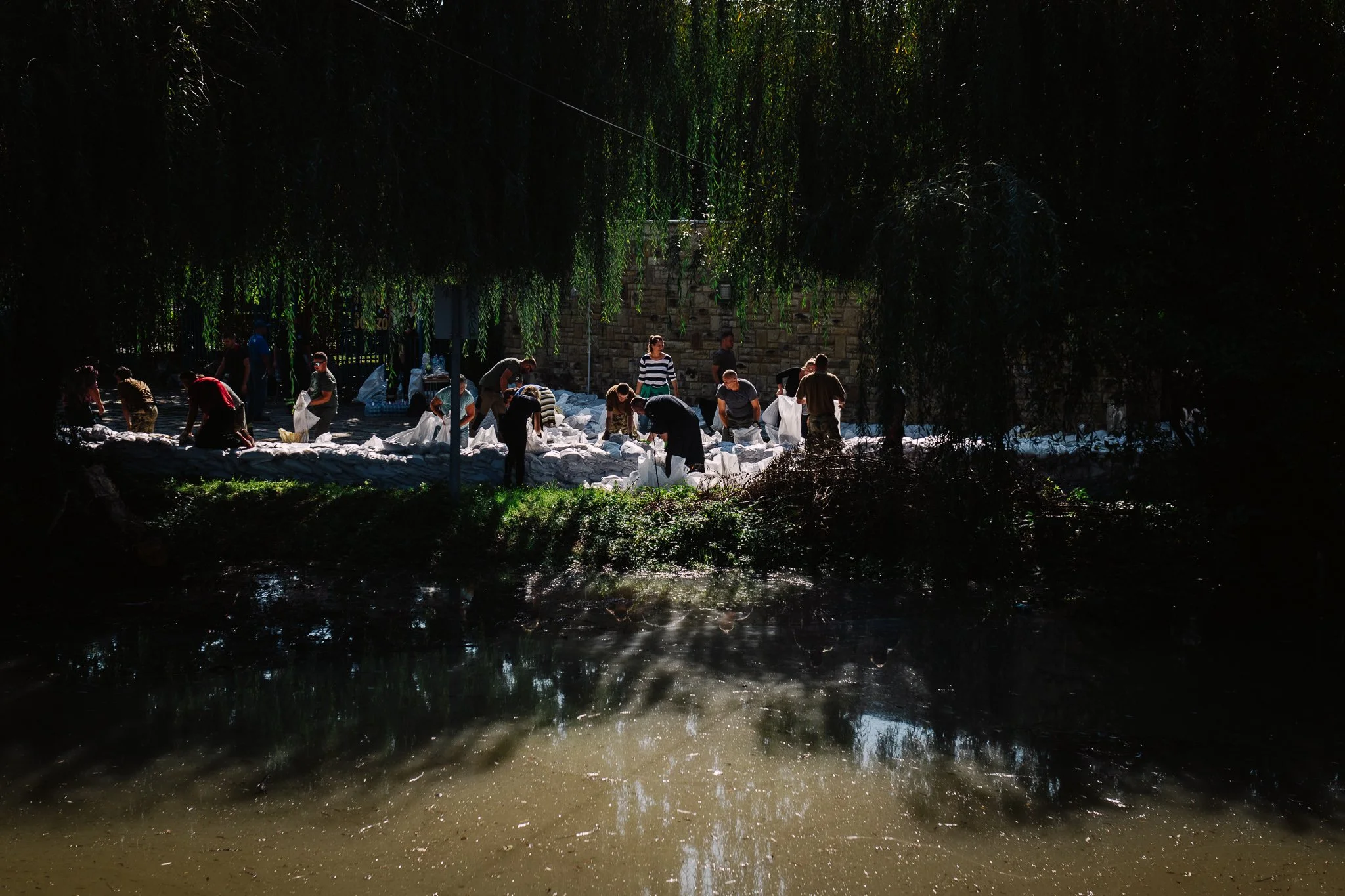Volunteers and soldiers build a barrier of sandbags between the Gombás stream and the city stadium on 19 September 2024.