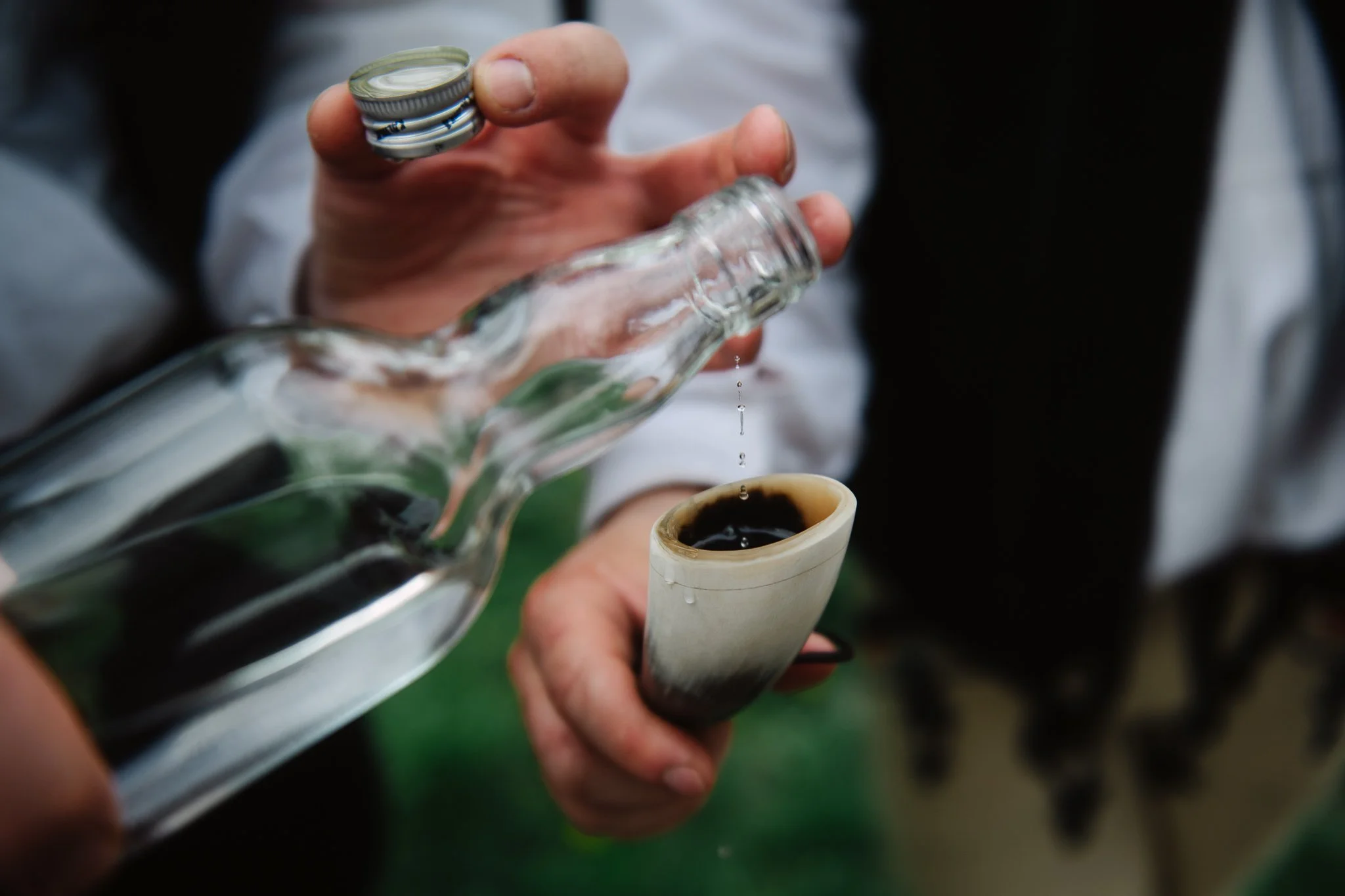 For one of the boys some pálinka is being to poured.