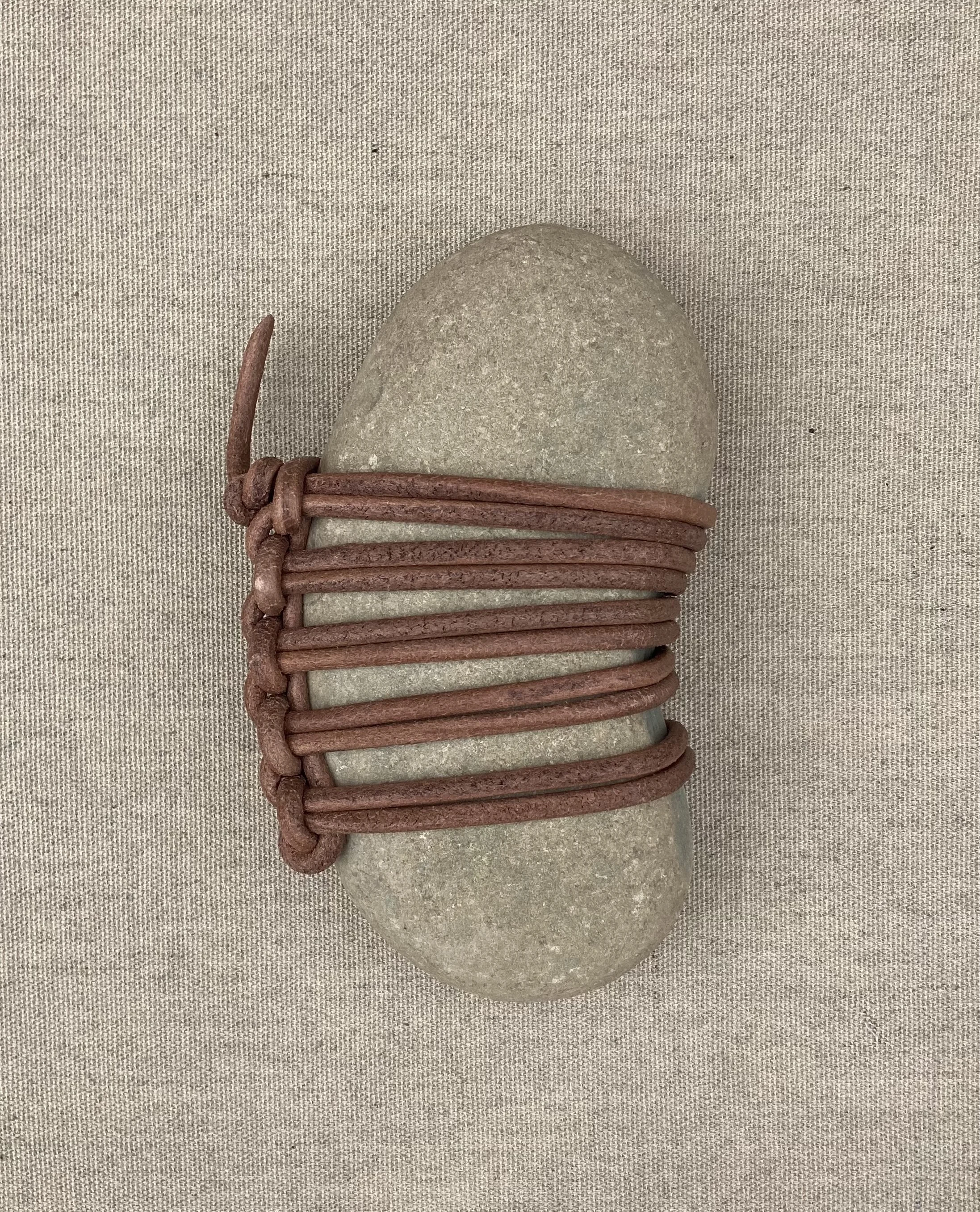 JIM OLARTE  
Small wrapped rock (6 available) (2025)  
Sizes vary: 6-8” long x 3-5” wide  
Rock wrapped in leather cord  
$350