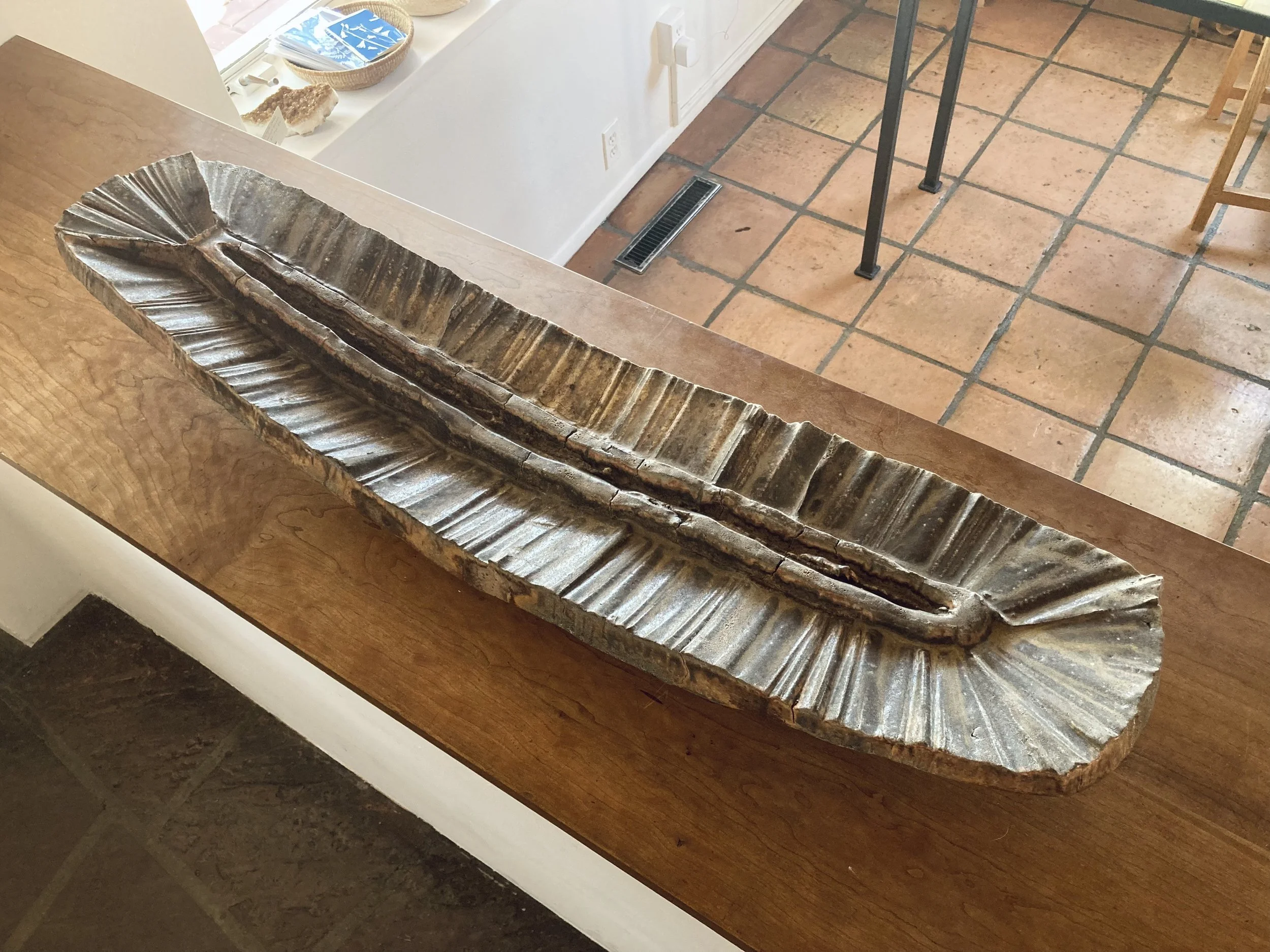 LOGAN WANNAMAKER  
Carved Sculpture (2026)  
36” x 9” x 3”  
Stoneware  
$3,600