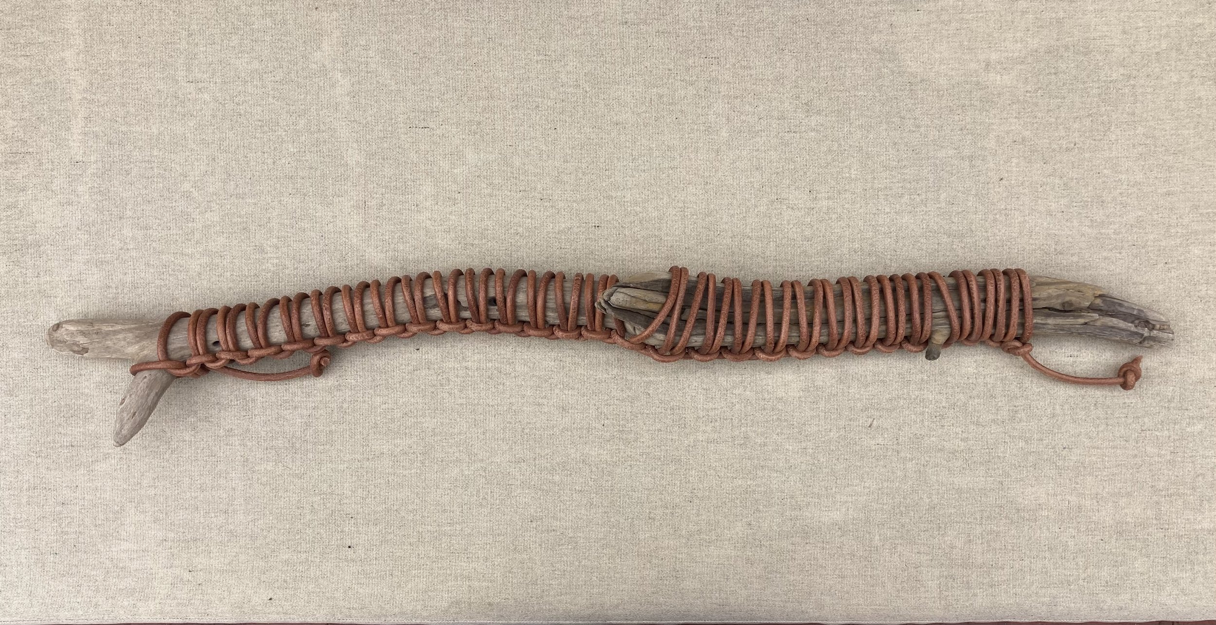 JIM OLARTE  
Wrapped driftwood 1 (2025)  
33.5” x 3”  
Driftwood wrapped in leather cord  
$500