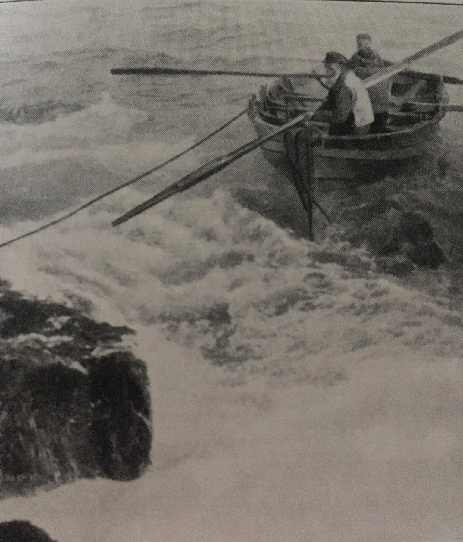 Black and white photograph of two men in a small boat with oars navigating through rough waters near a large rock.