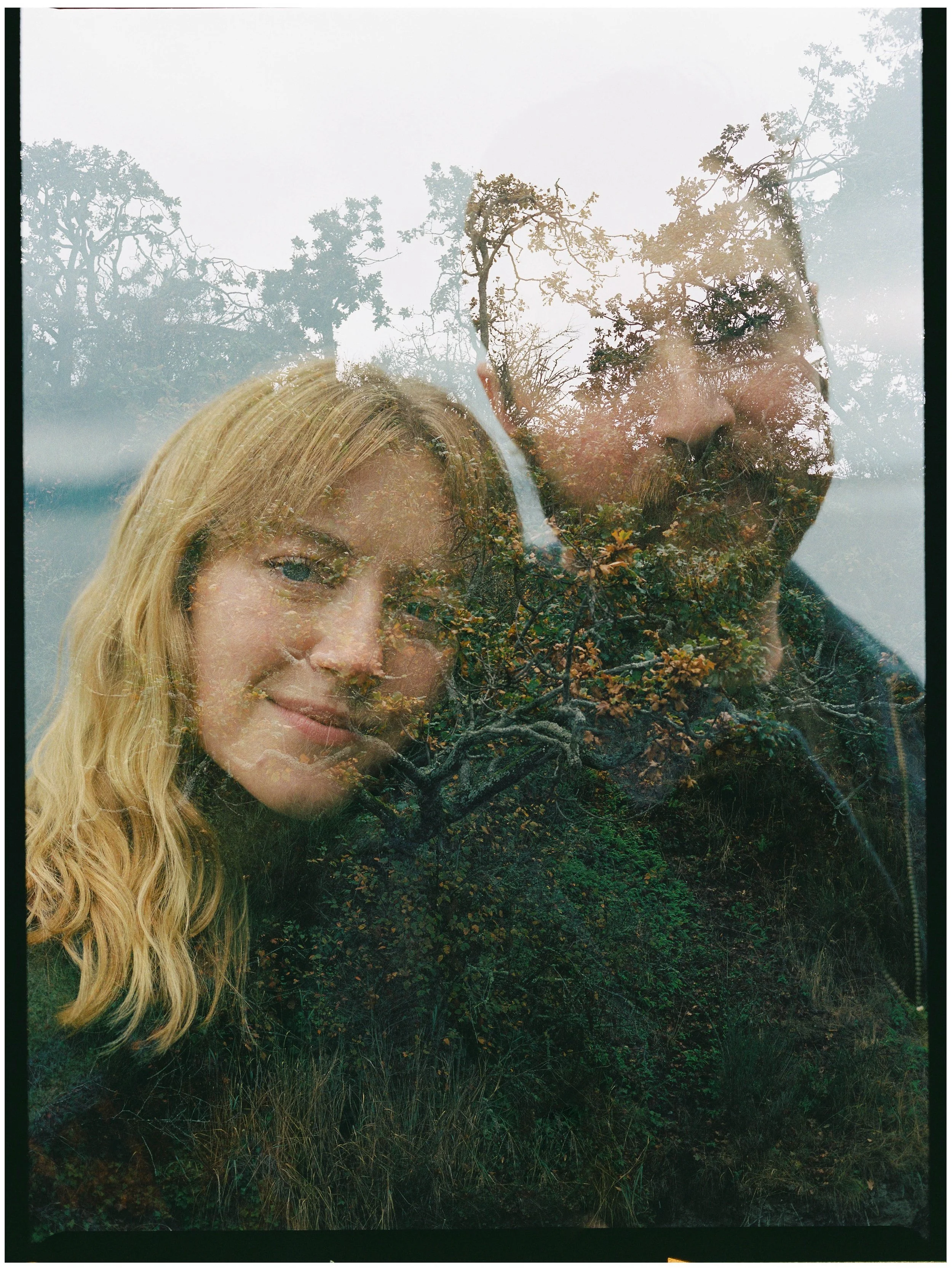 A double exposure photo combining a portrait of a blonde woman smiling with a landscape of trees and foliage.