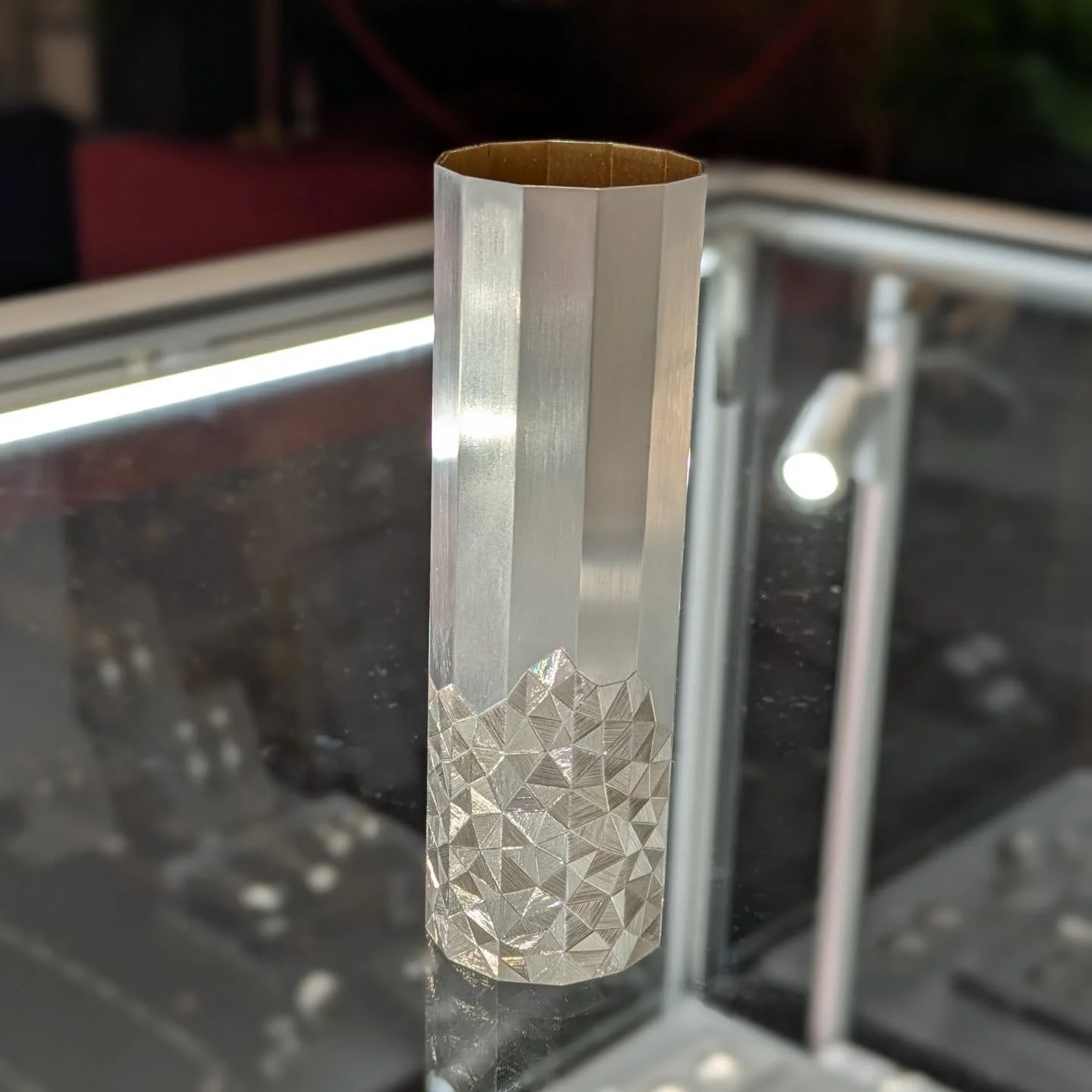 Little silver vase! Scored, folded and hand engraved with the faceted design to give the illusion of a 3D surface. Come along and see all the wonderful work on display at Goldsmiths' Hall in London. We are open and ready for day 3 of @goldsmithsfair!