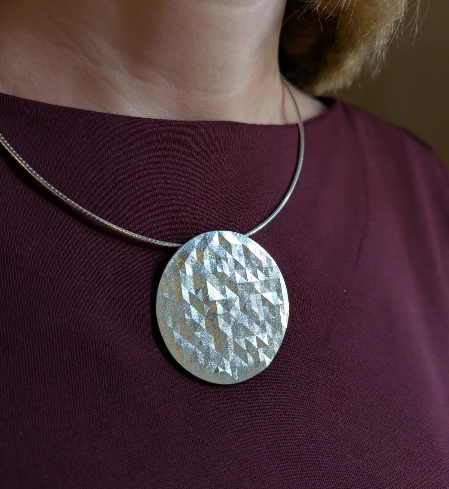 New faceted circluar necklace reflecting the light in the beautiful Goldsmiths' Hall @goldsmithsfair.

#goldsmithfair #goldsmithsfair2025 #silverbudvase #facetedvase #handengraved #contemporarysilversmithing  #contemporarybritishsilver #geometricdesi