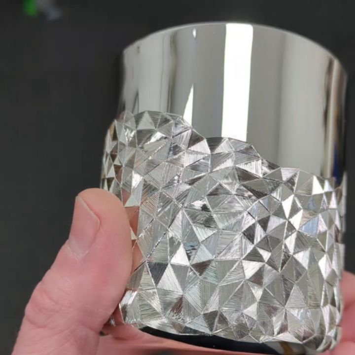 Playing with lines and light to create the illusion of a three-dimensional surface.

Designed as a response to the digital processes I use to create my faceted pieces, each line is hand-engraved in varying directions to catch and reflect light and cr