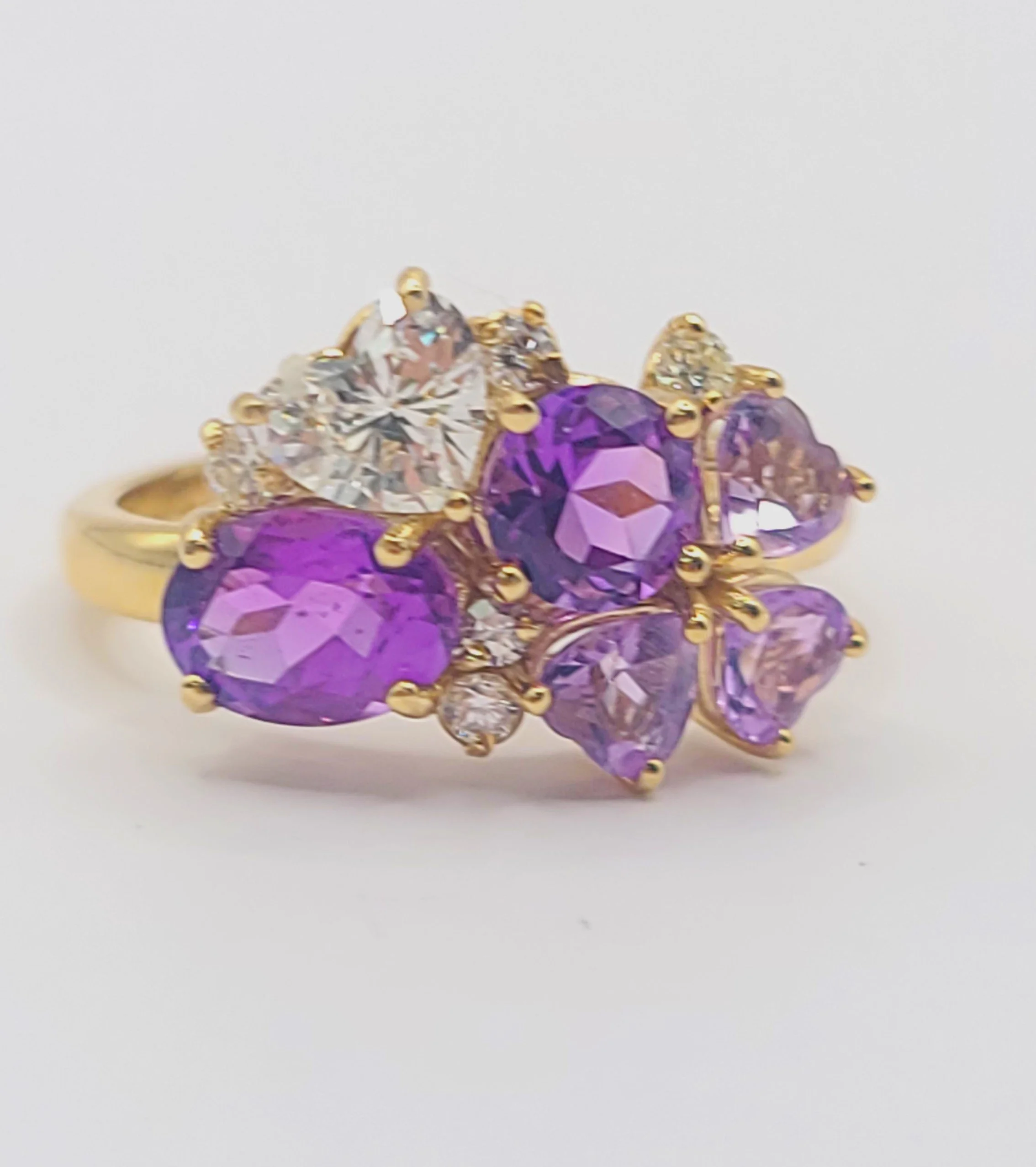 Photo of custom-designed amethyst and diamond ring set in yellow gold, various shapes and sizes of stones 