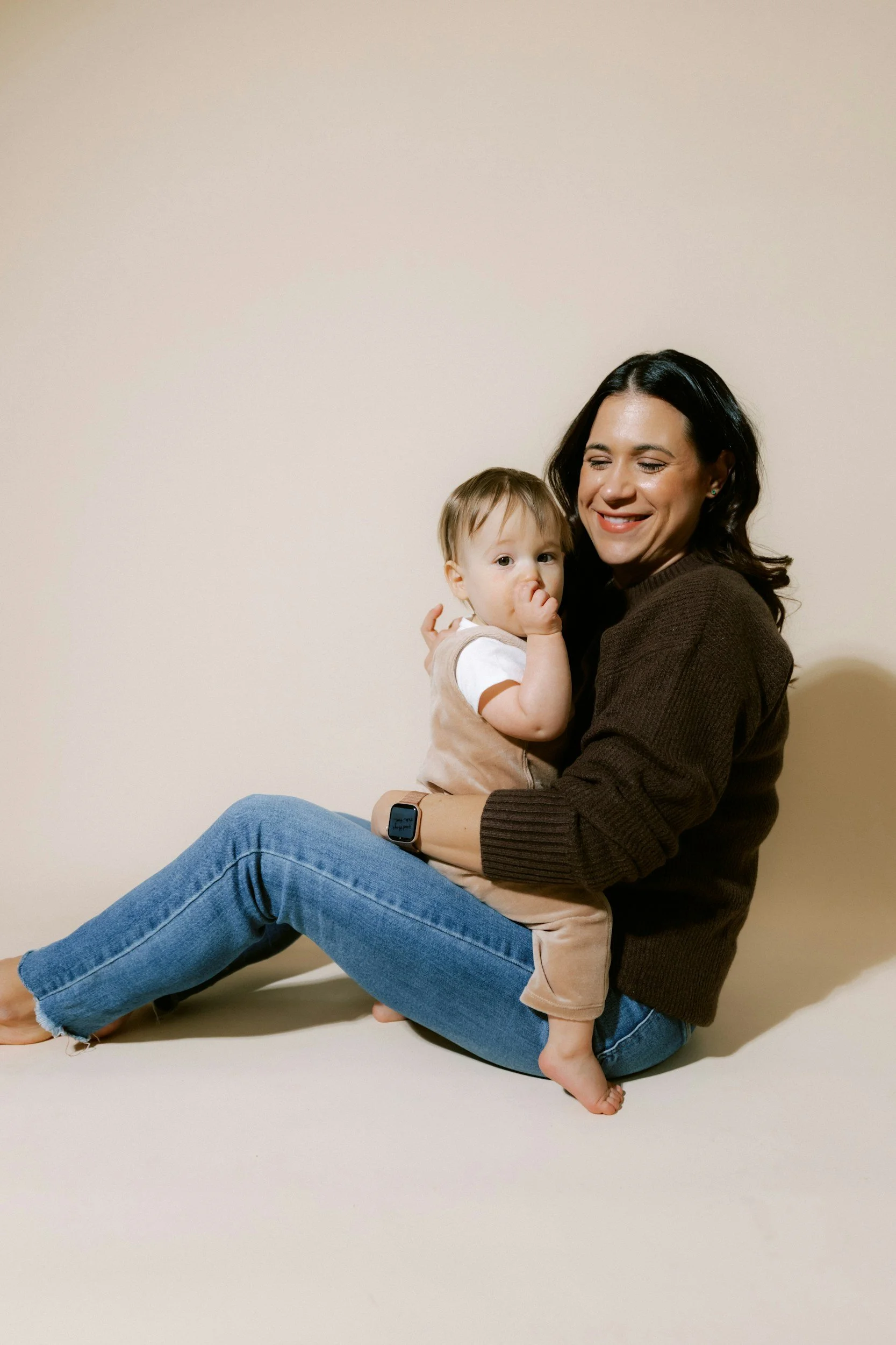 Mother holding her young daughter while navigating postpartum challenges.