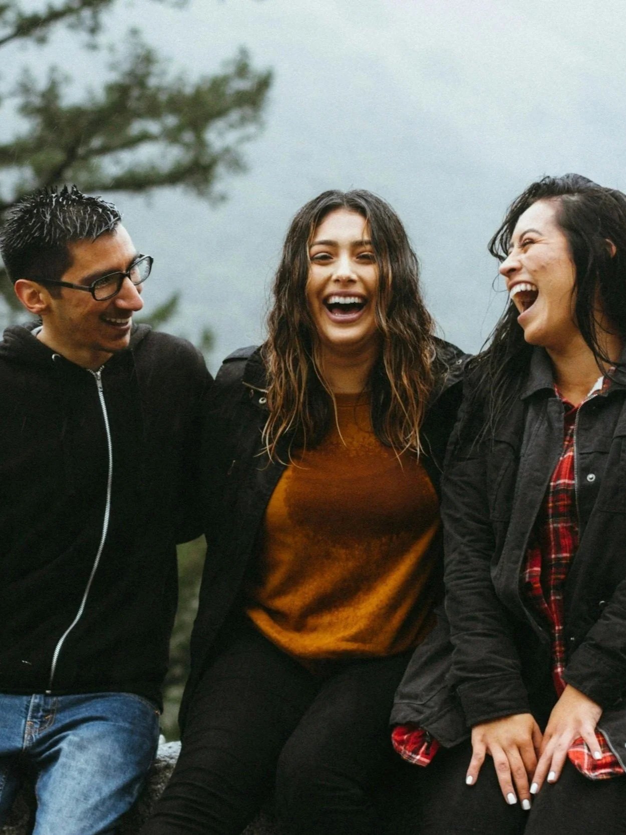 Friends laughing and connecting outdoors, representing connection and emotional well-being.