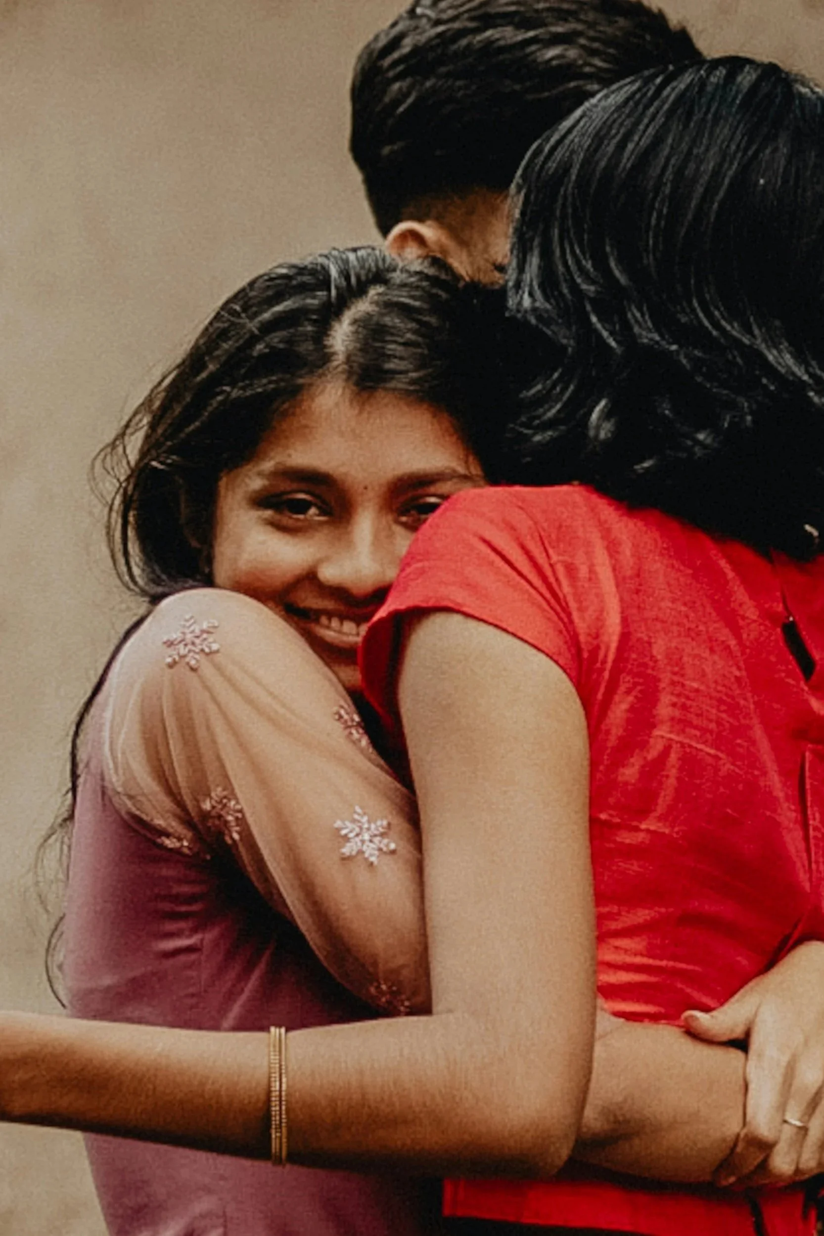 Indian woman hugging another woman, representing connection and support.