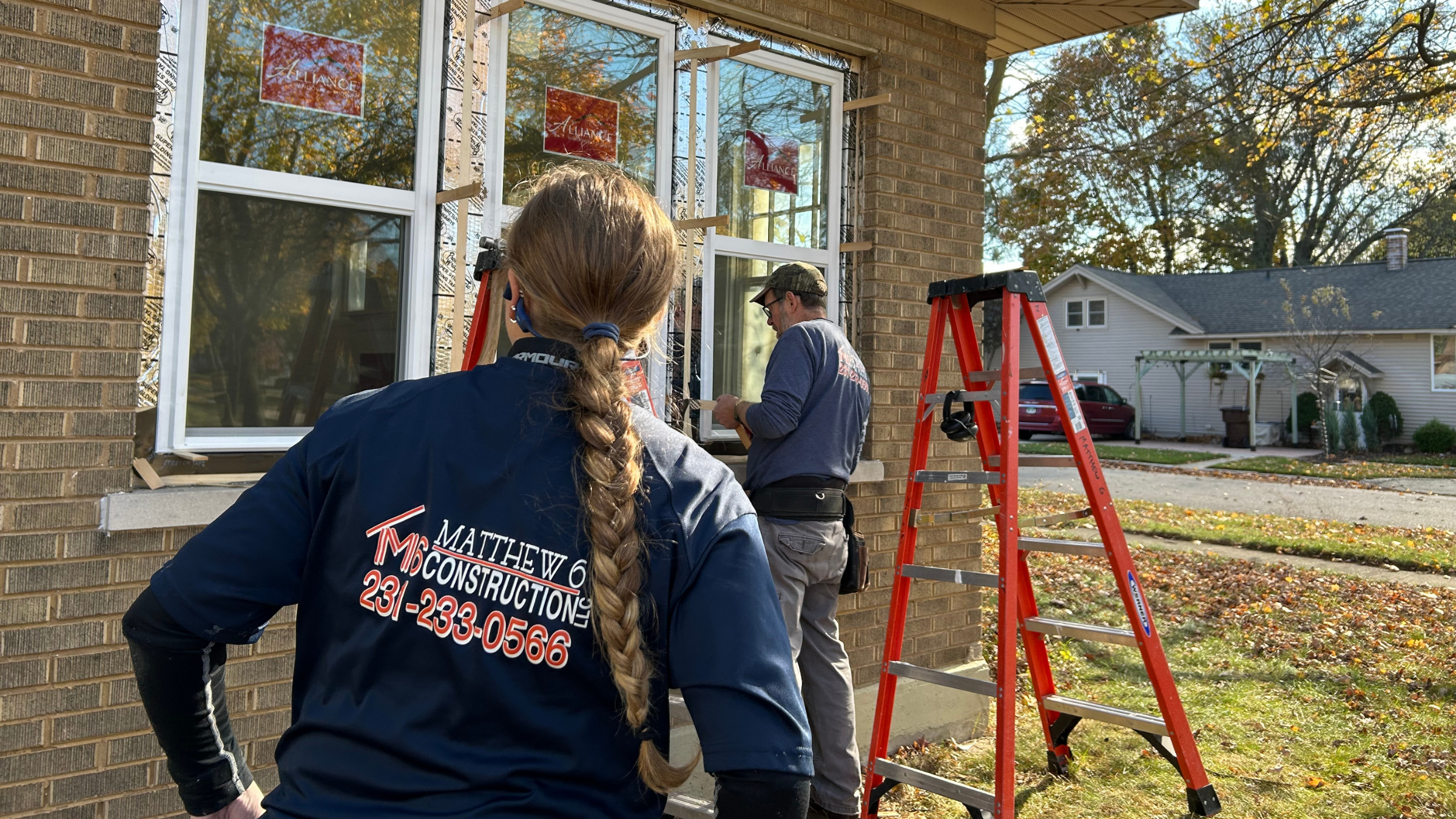 Window installation crew from Matthew 6 Construction installing Alliance replacement windows in downtown Ludington Michigan