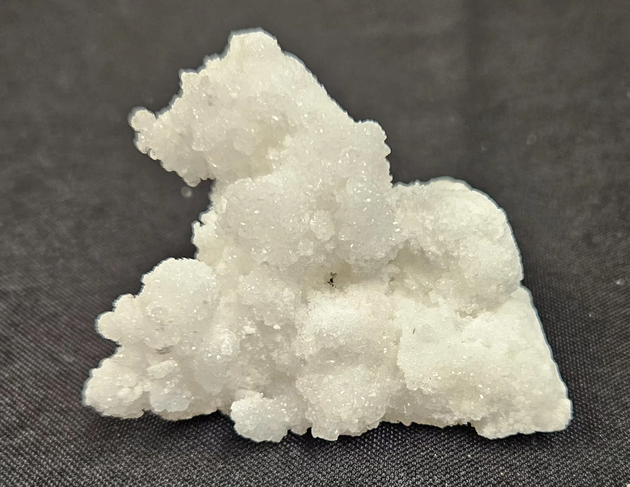 White Aragonite crystal with soft milky-white colouring and natural clustered structure, showing a clean, calming mineral texture.