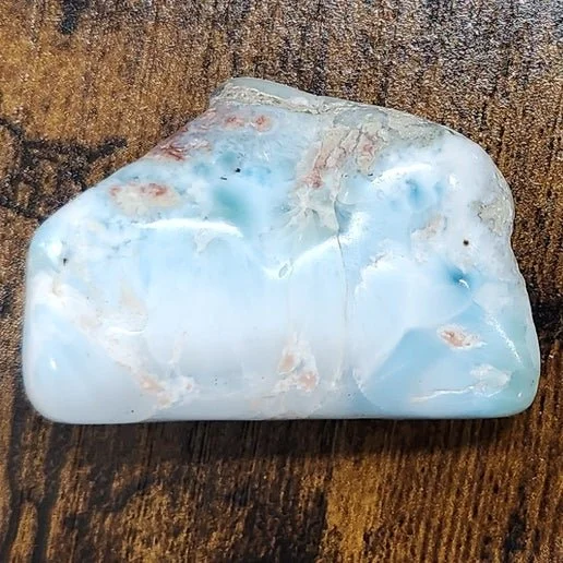 Soft blue and white larimar stone with natural ocean-like marbling and polished finish.