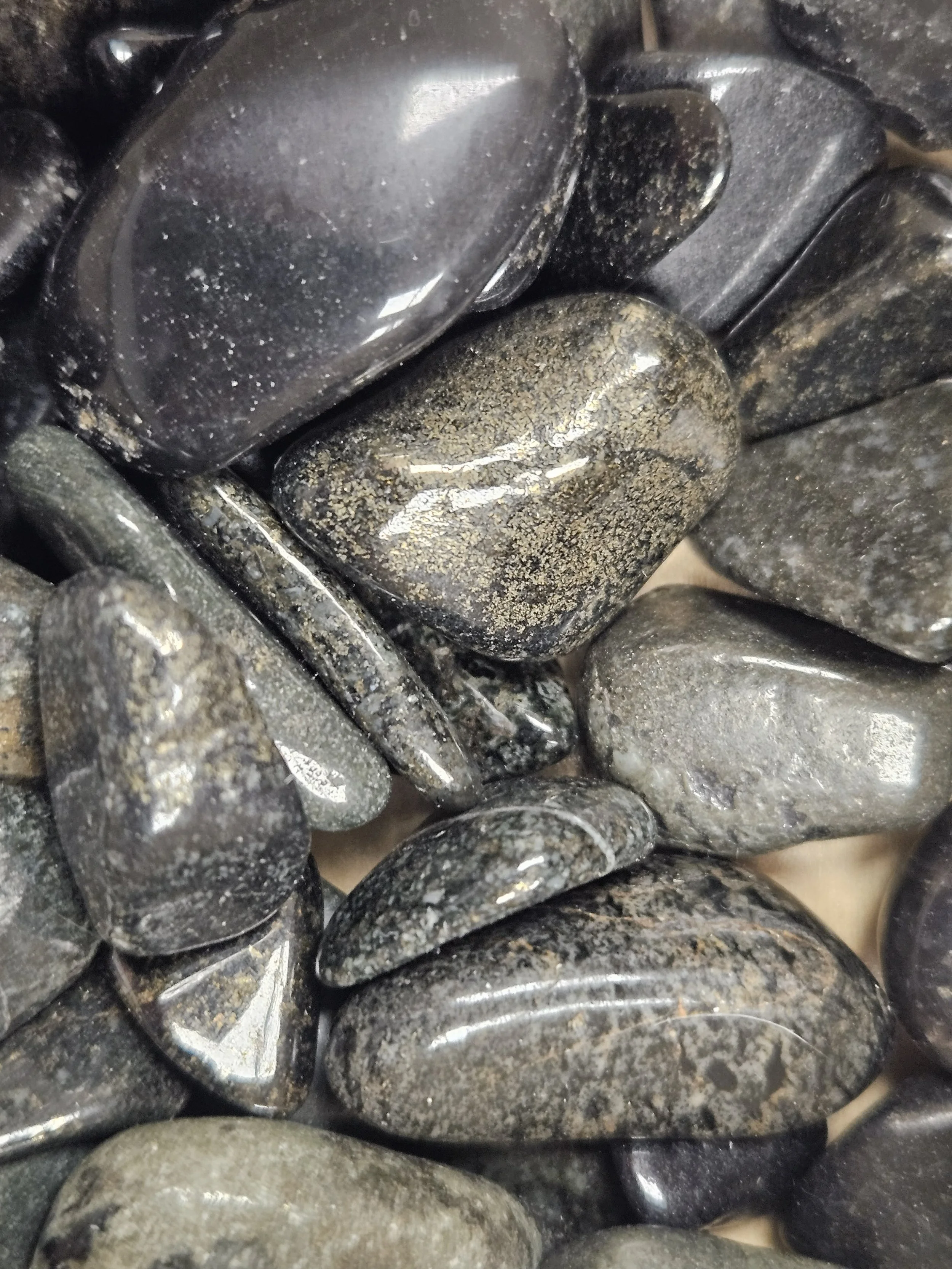 A polished Black Lemurian Jade stone with deep charcoal to black colouring and a smooth, natural surface.