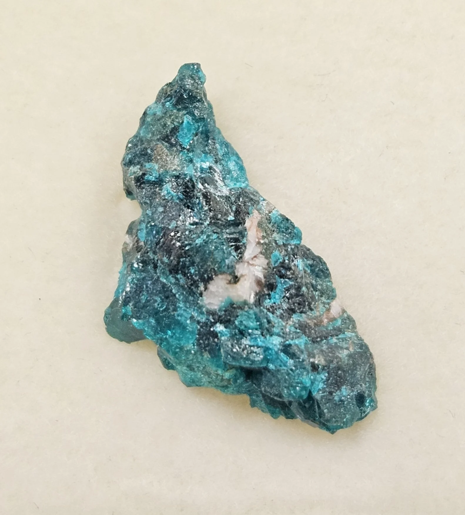 Vivid green Dioptase crystals on rocky matrix showing natural copper-based mineral formations.