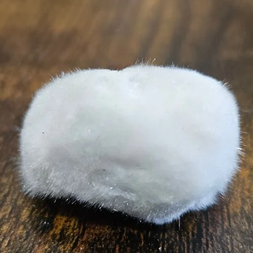White fluffy Okenite crystal cluster on dark matrix, showing delicate fibrous cotton-like formations.