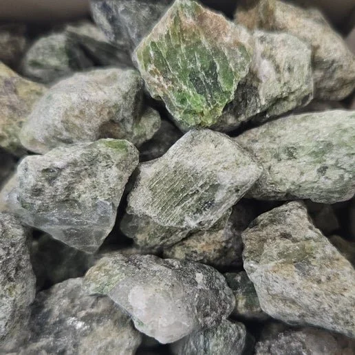 Green Diopside crystal showing natural translucency and earthy tones in polished and raw forms.